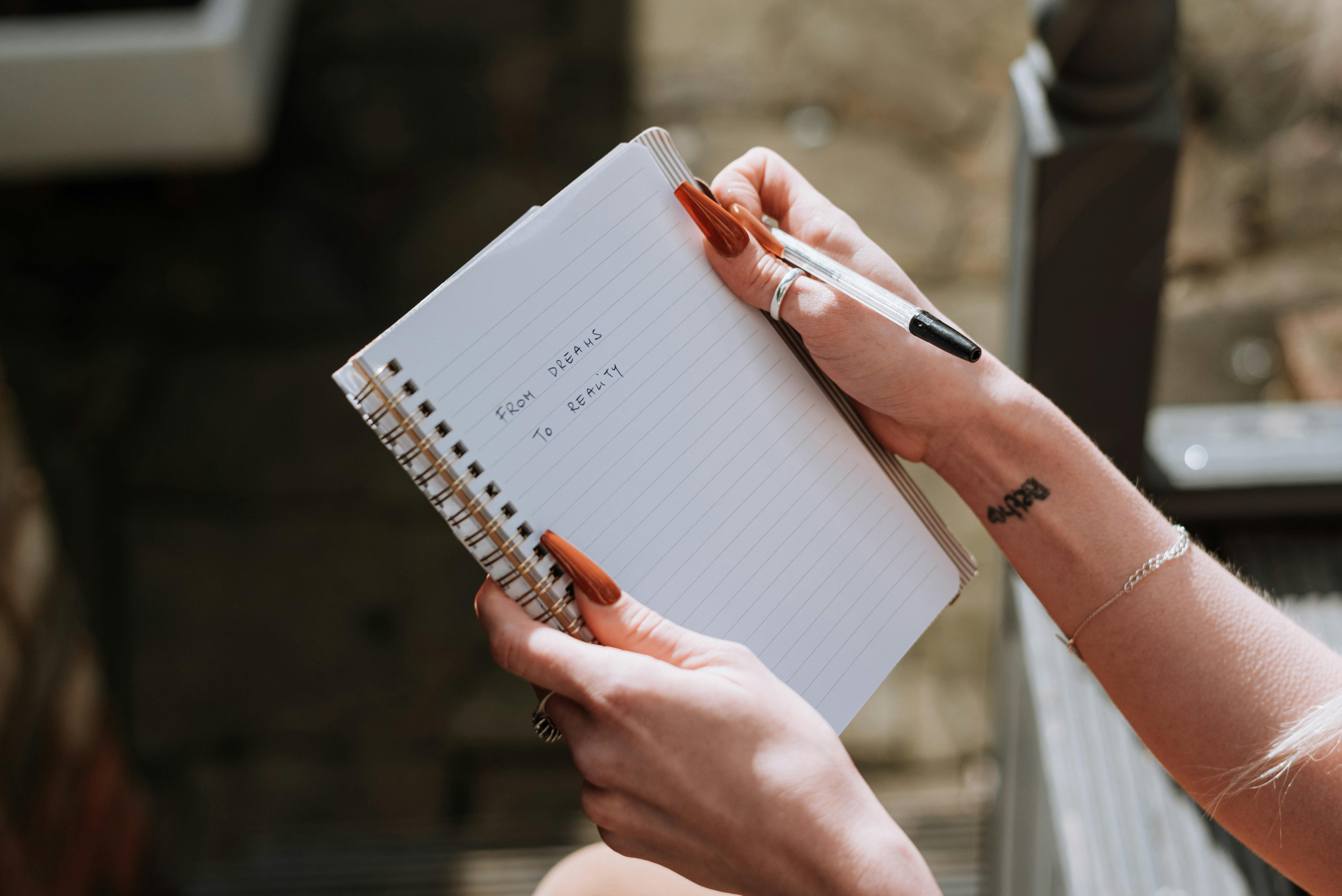 Una mujer sostiene un cuaderno | Fuente: Pexels