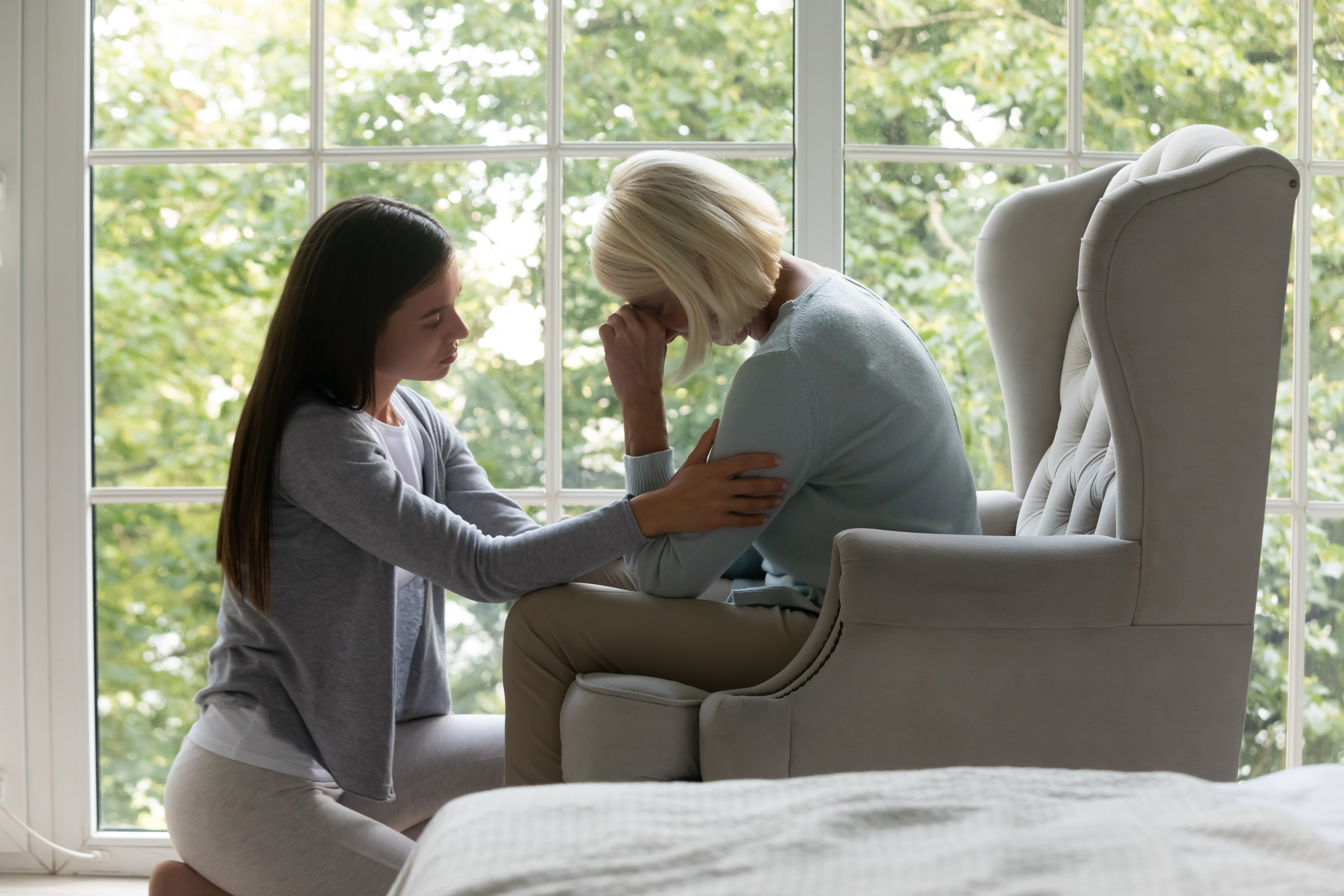 Una joven consuela a su madre anciana y deprimida | Fuente: Shutterstock