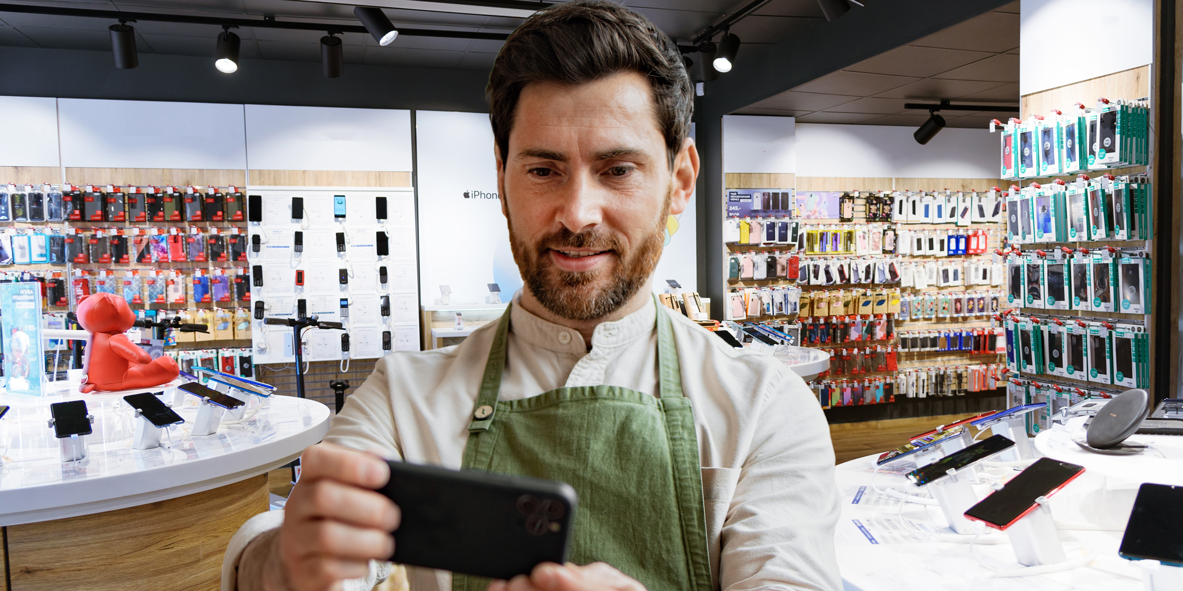 Un hombre mirando un teléfono en una tienda | Fuente: Shutterstock