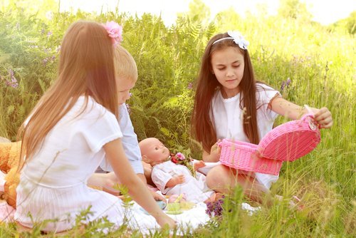 Niñas jugando con sus muñecas al aire libre. | Fuente: Shutterstock.