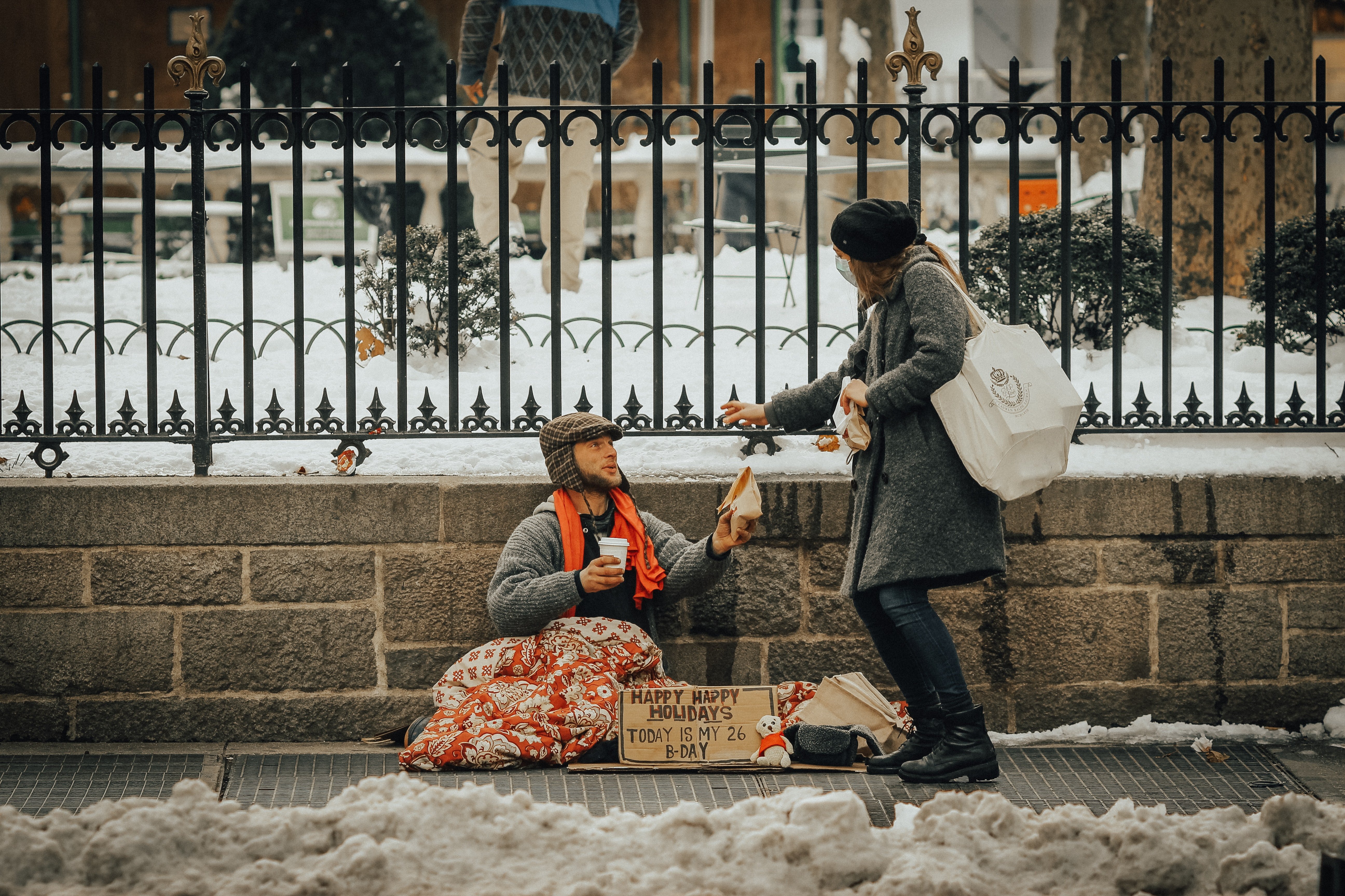 Un indigente pide comida a una señora en la calle. | Foto: Unsplash