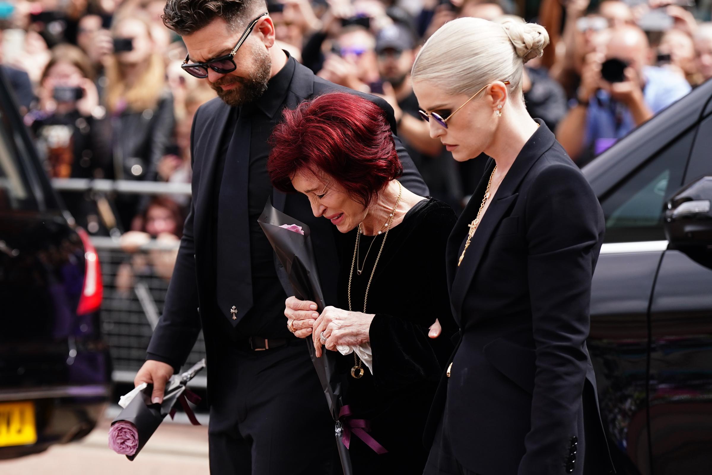Sharon, Jack y Kelly depositan flores en el banco del puente de Black Sabbath en Broad Street, Birmingham, el 30 de julio de 2025 | Fuente: Getty Images