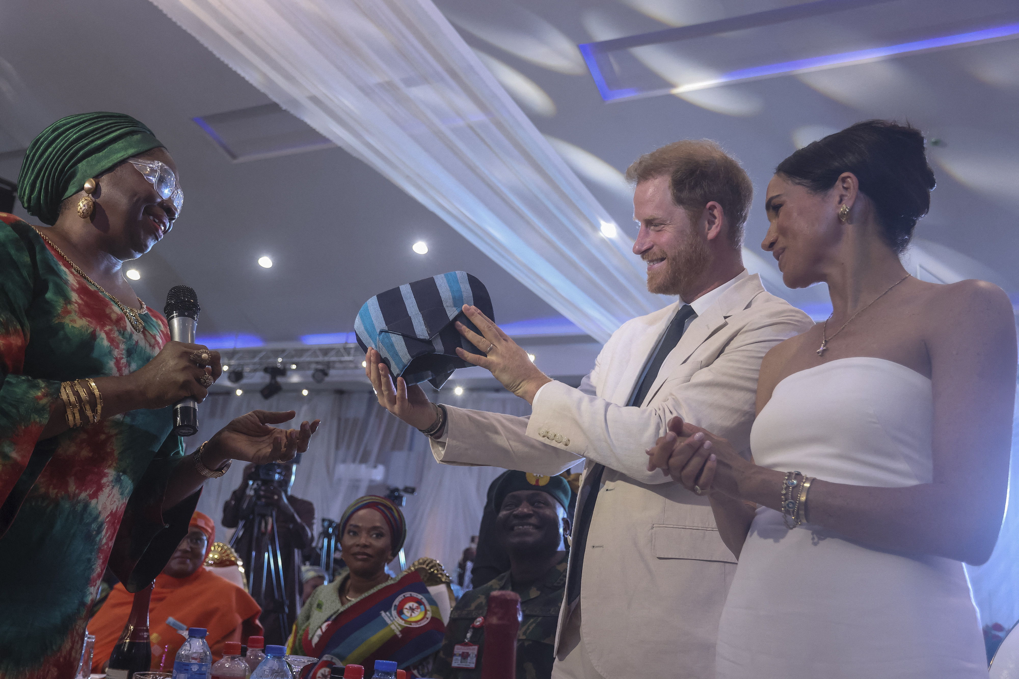 El príncipe Harry y Meghan Markle reciben un traje tradicional mientras asisten a una Sentada en el Cuartel General de Defensa de Nigeria en Abuja el 11 de mayo de 2024, en Nigeria | Fuente: Getty Images