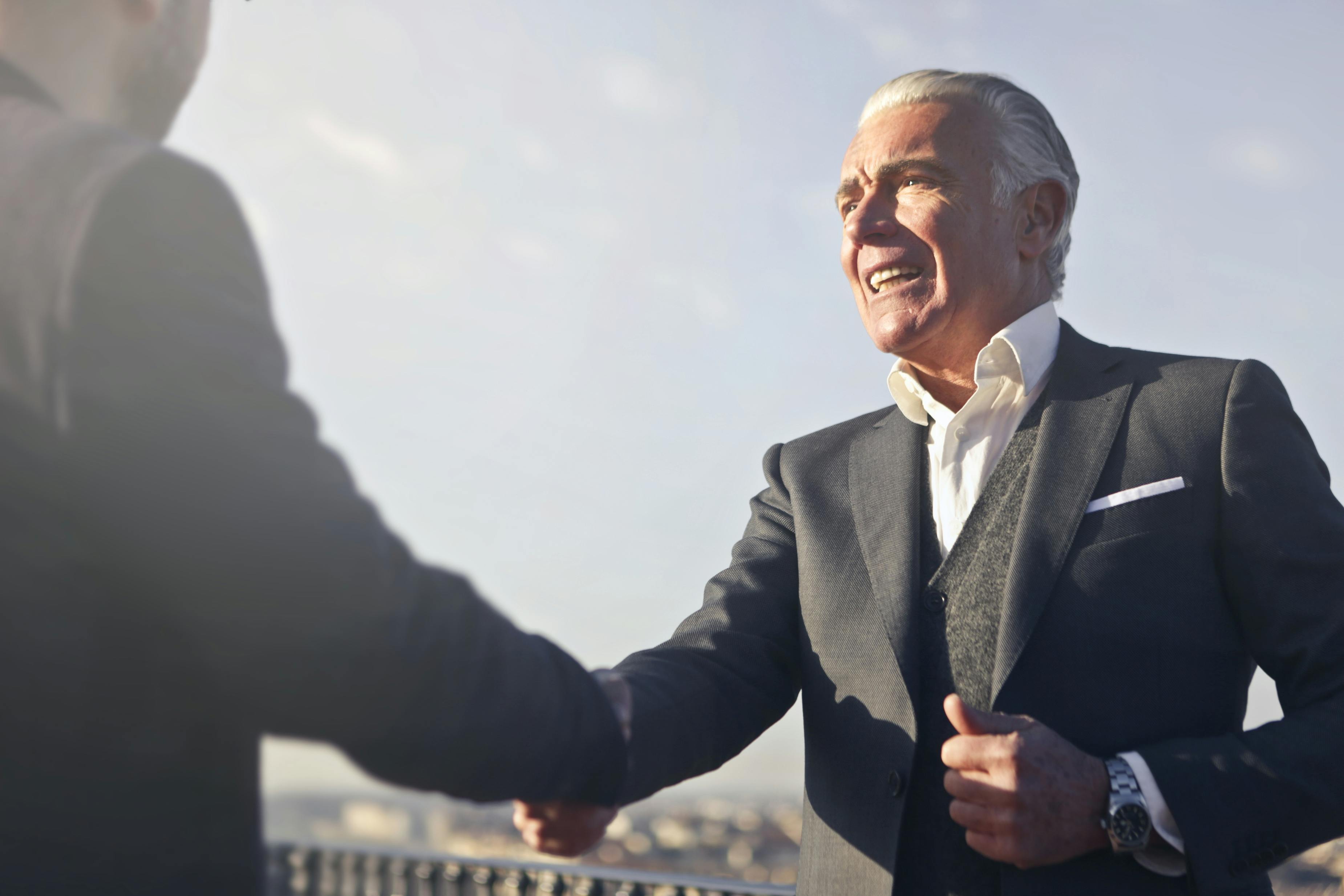 Dos hombres se dan la mano en la presentación | Fuente: Pexels