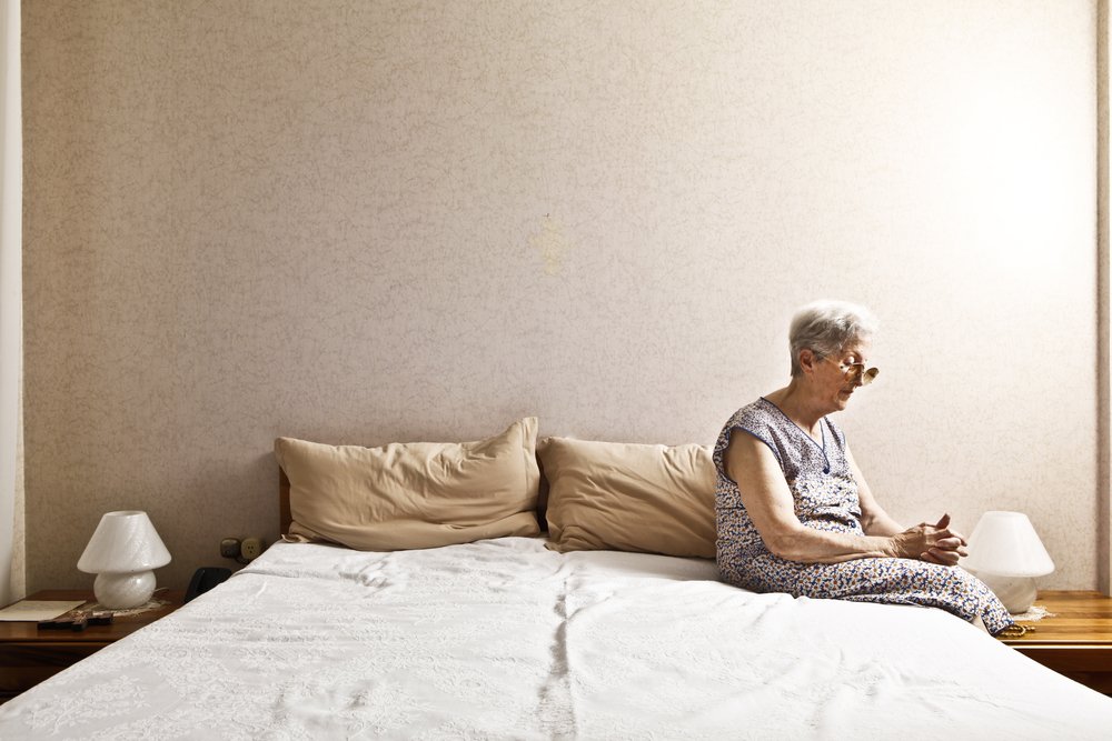 Anciana sentada al borde de su cama. I Foto: Shutterstock.