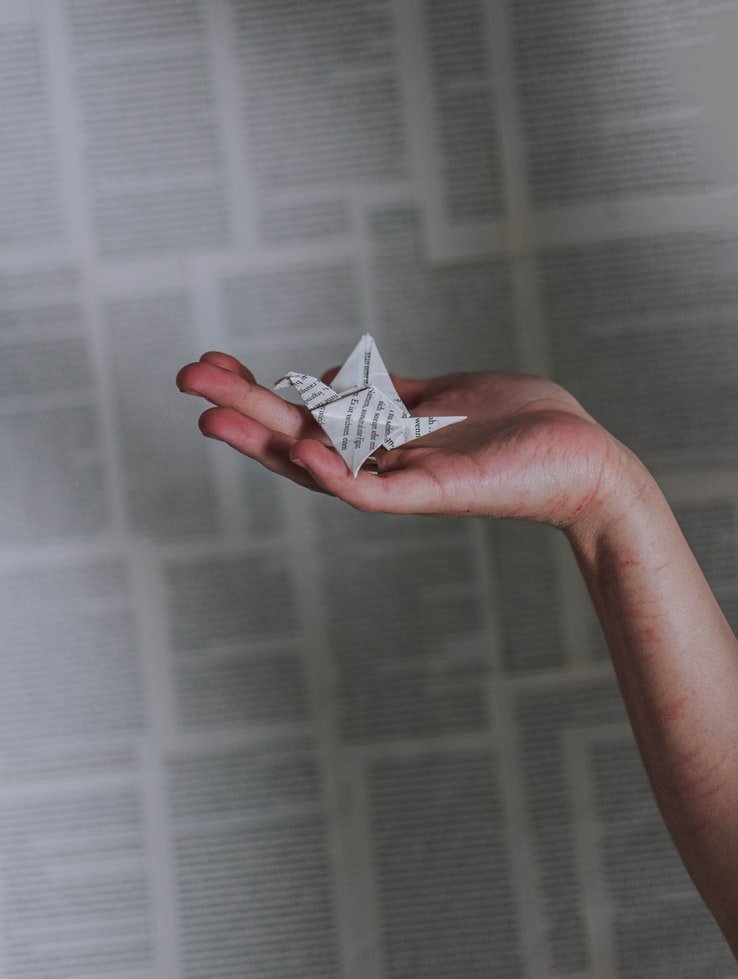 Persona sosteniendo un origami en su mano. | Foto: Unsplash