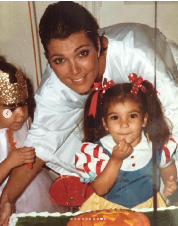 Una joven Kris Jenner posa con sus hijas Kourtney y Kim Kardashian en una fiesta de cumpleaños familiar; Kourtney está de pie delante de ella, junto a un pastel de cumpleaños. Kris lleva una camiseta blanca, mientras que las chicas van vestidas con conjuntos de colores. | Fuente: Instagram/krisjenner