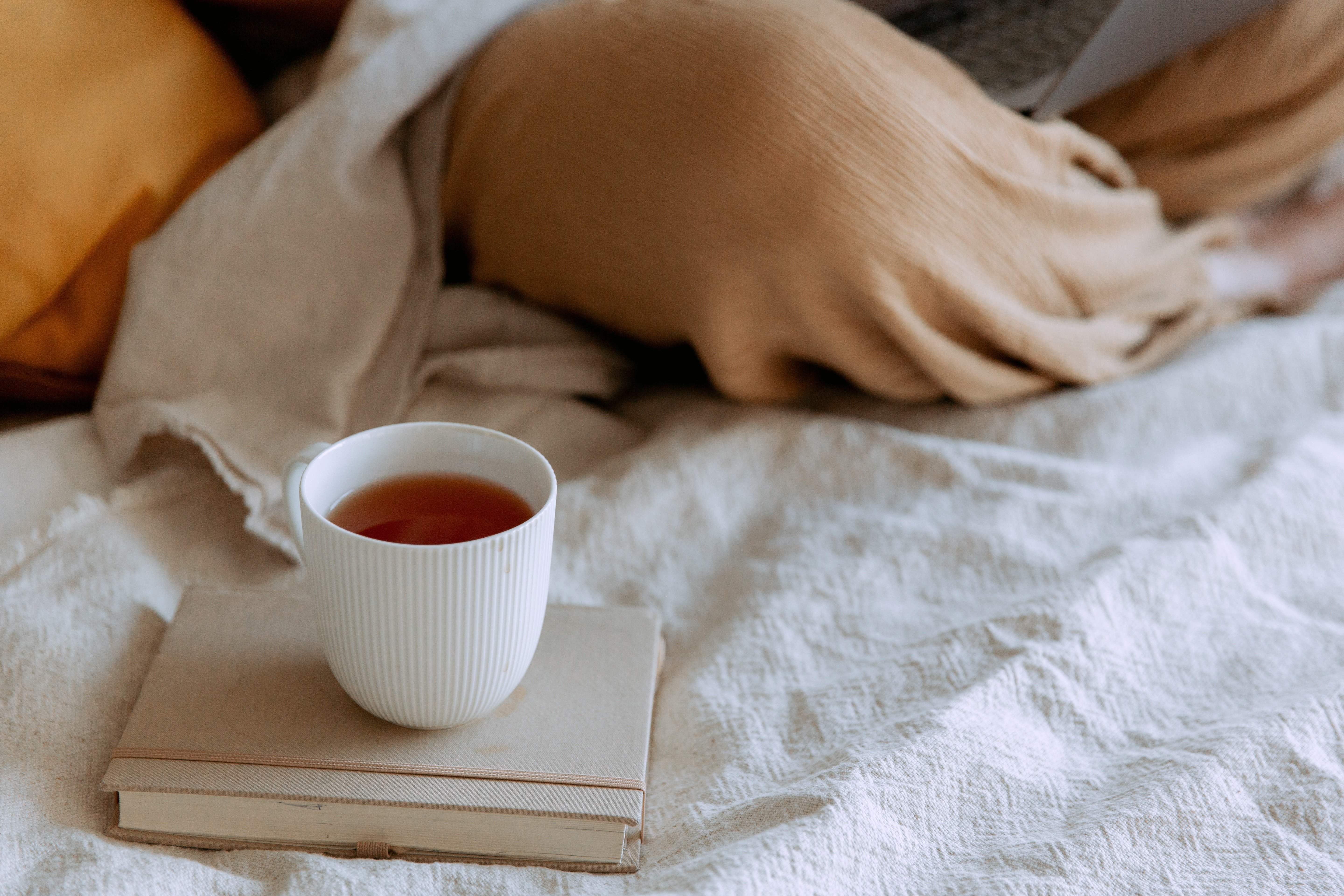 Una taza de té sobre una cama | Fuente: Pexels