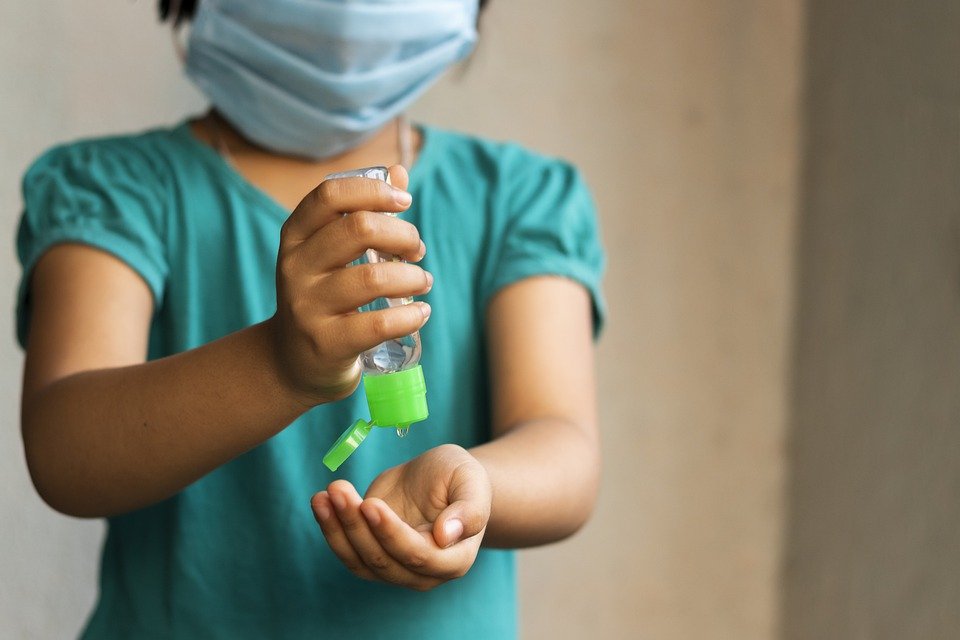 Niña usando tapabocas y antibacterial en sus manos. | Foto: Pixabay