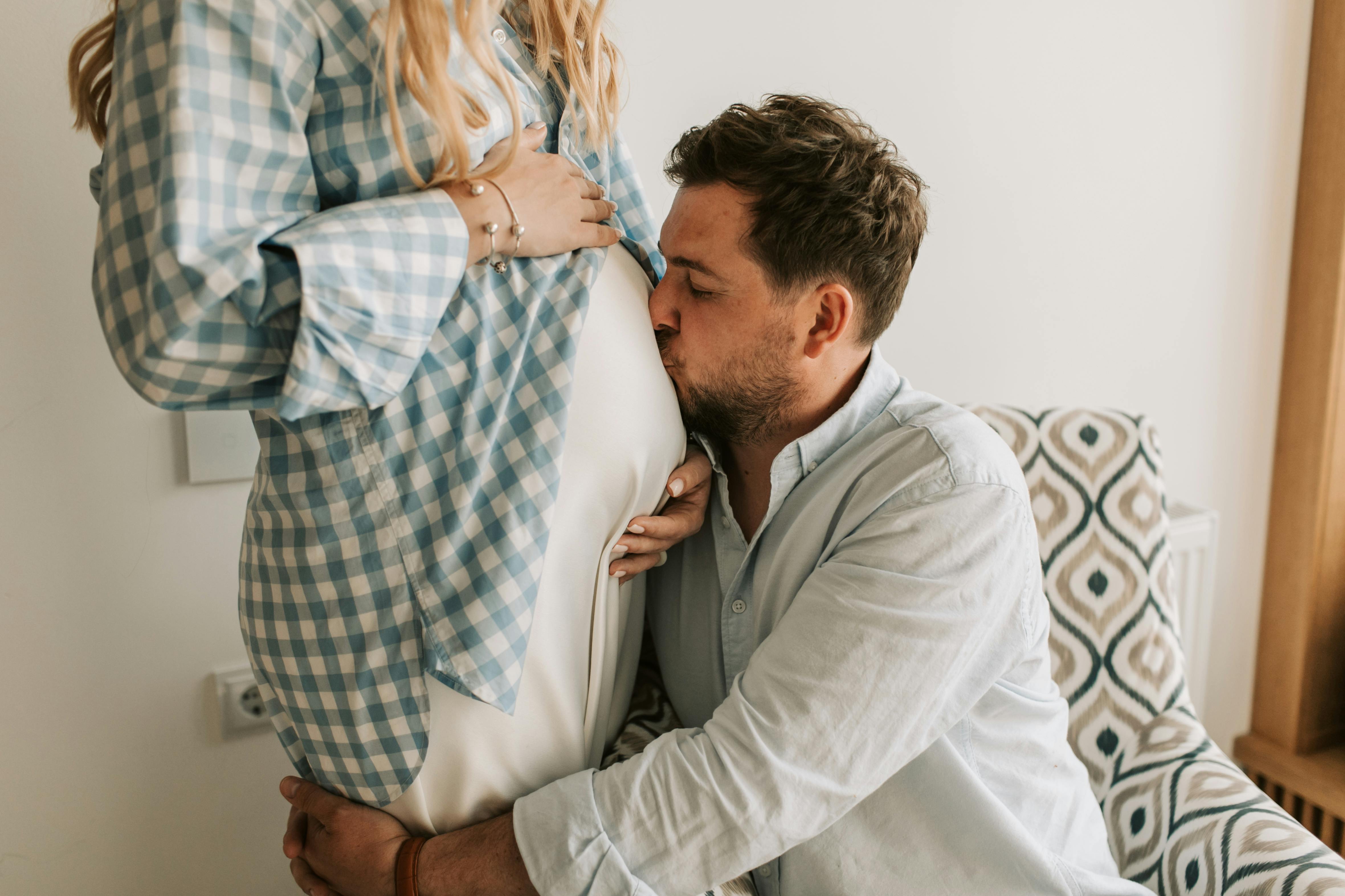 Un hombre mimando a su mujer embarazada | Fuente: Midjourney
