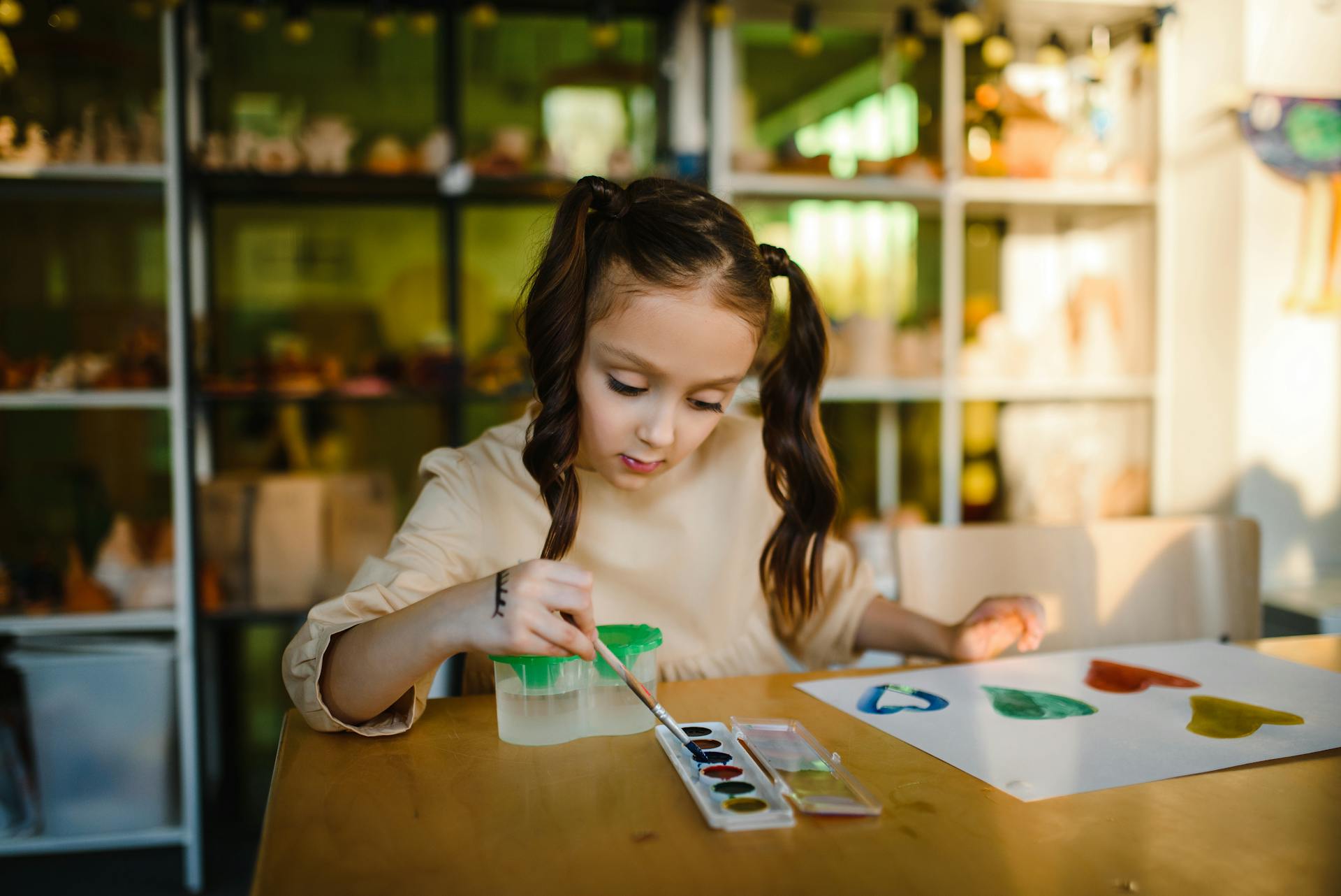 Una niña pintando un cuadro en un papel | Fuente: Pexels