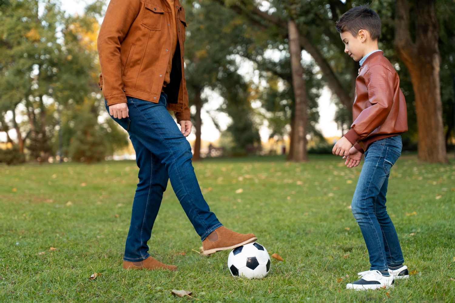 Un niño jugando al fútbol con su padre | Fuente: Freepik
