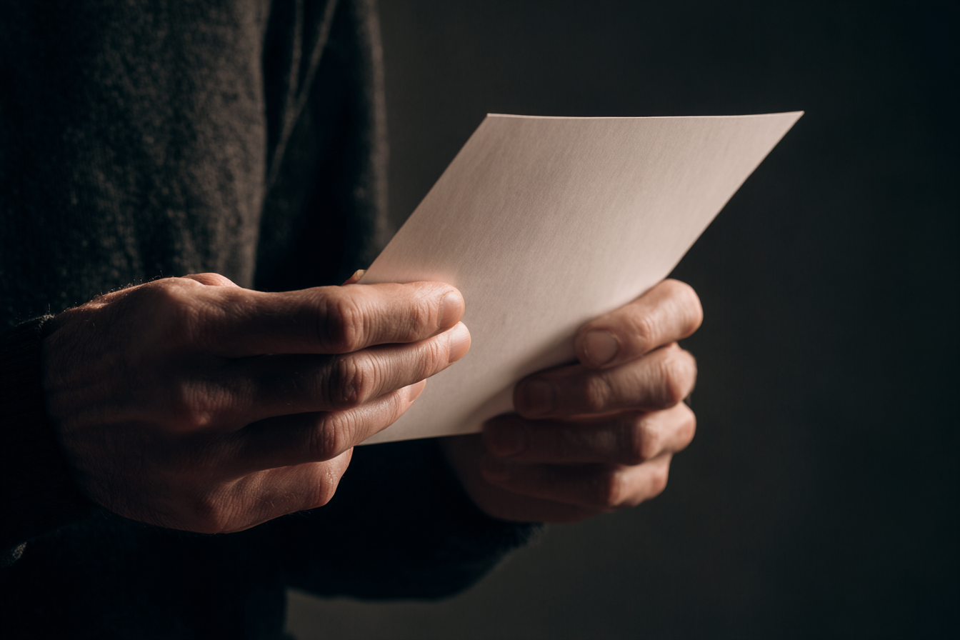 Un hombre sostiene un papel | Fuente: Midjourney