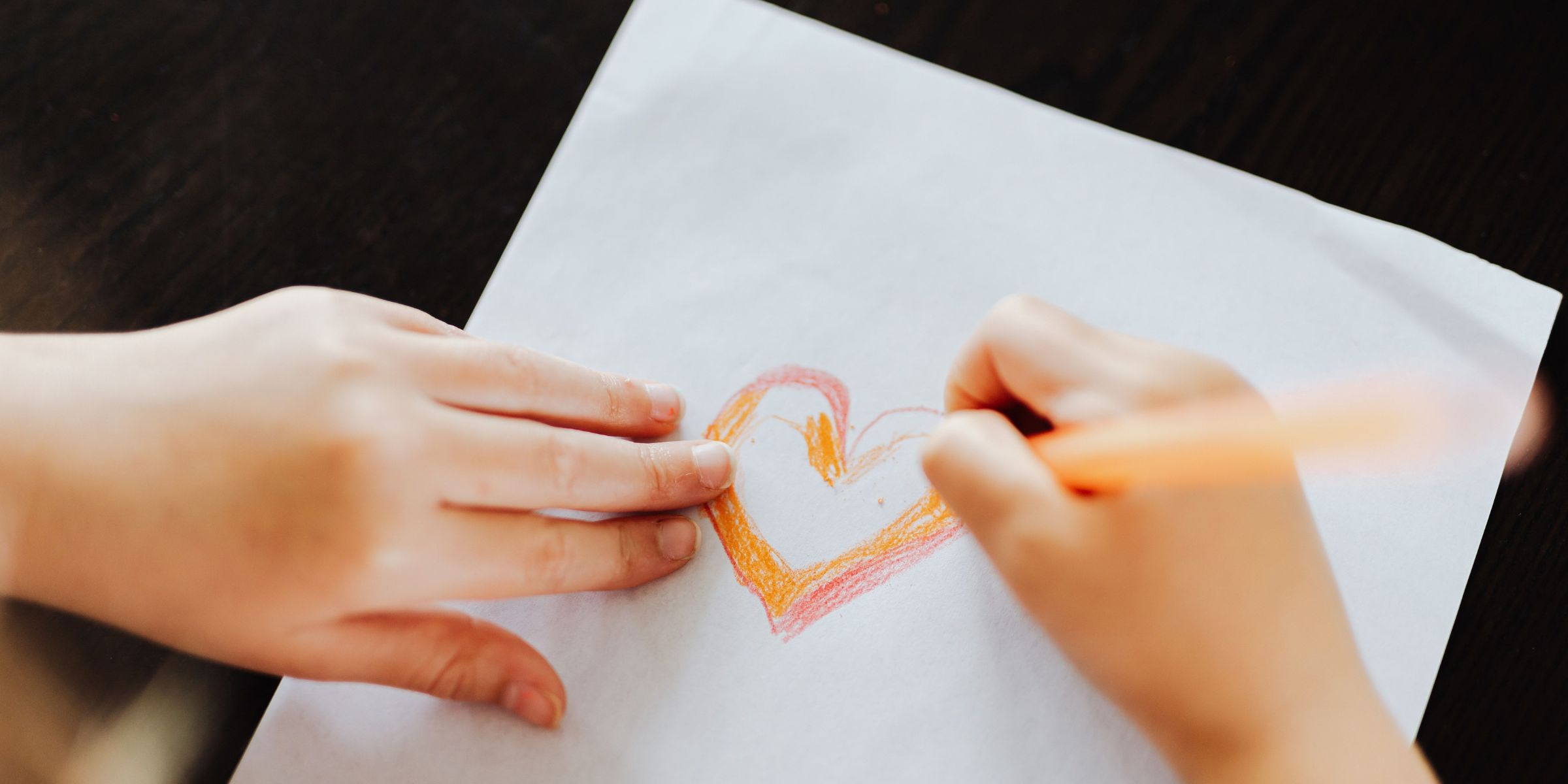 Una niña dibujando corazones | Fuente: Pexels