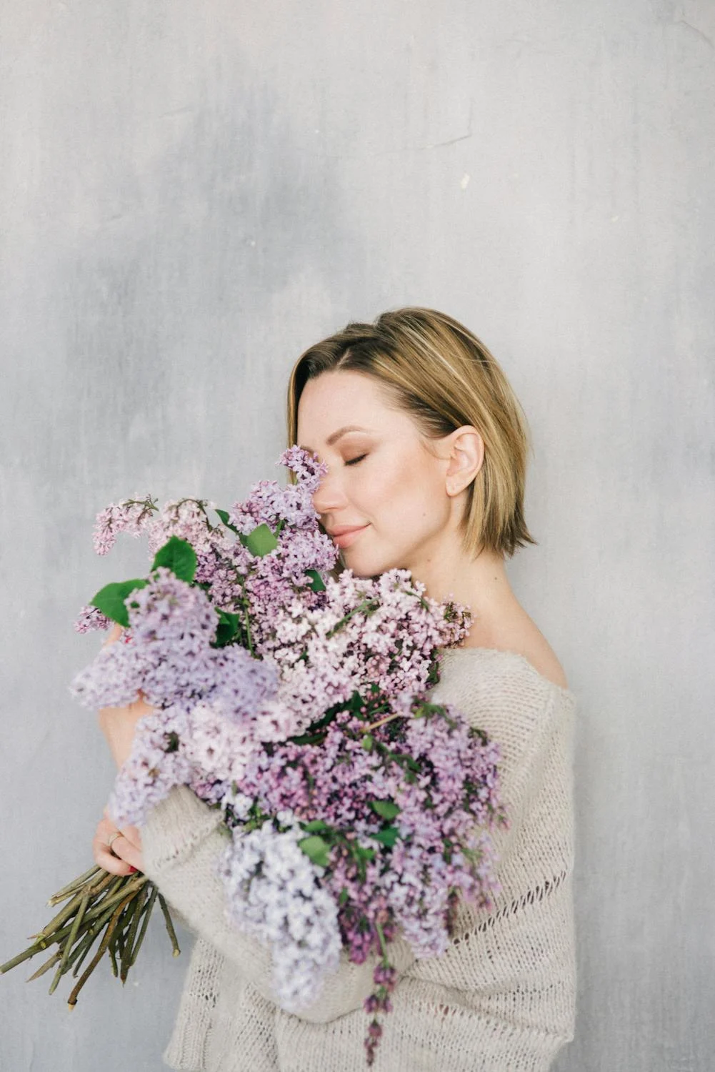 Una mujer oliendo flores | Fuente: Pexels