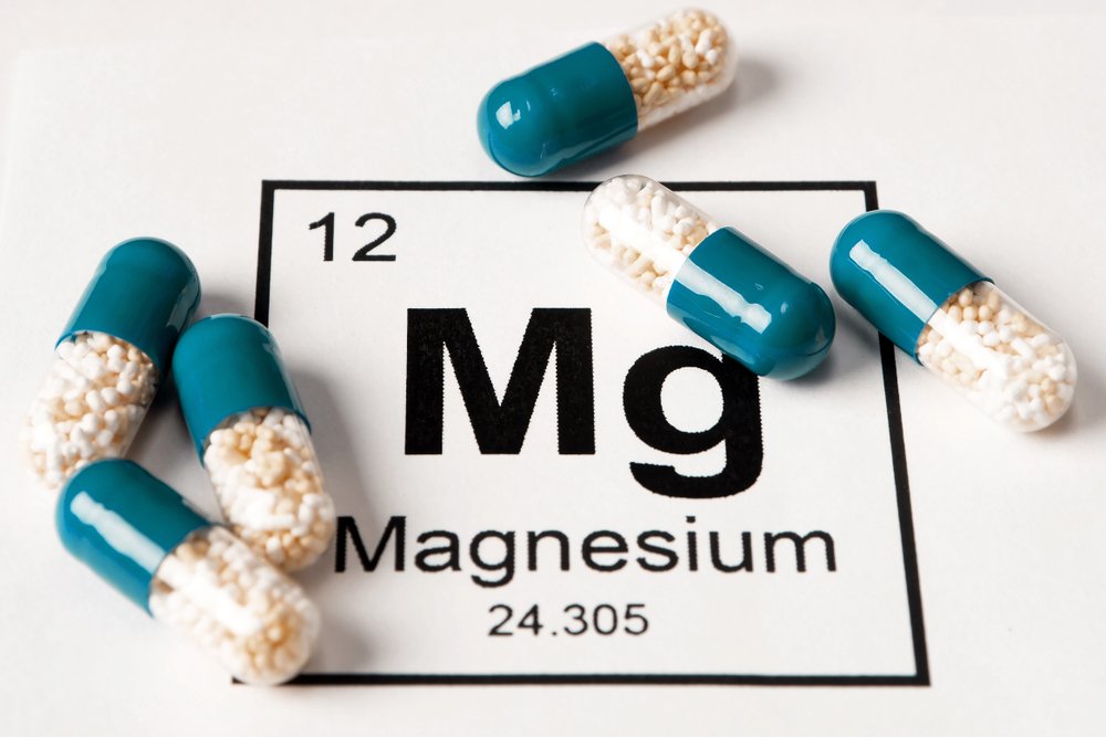 Símbolo químico del magnesio y cápsulas. || Fuente: Shutterstock