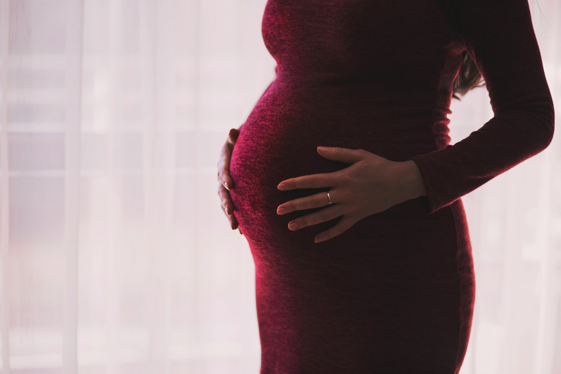 Una foto recortada de una mujer embarazada sujetando su panza. | Fuente: Unsplash