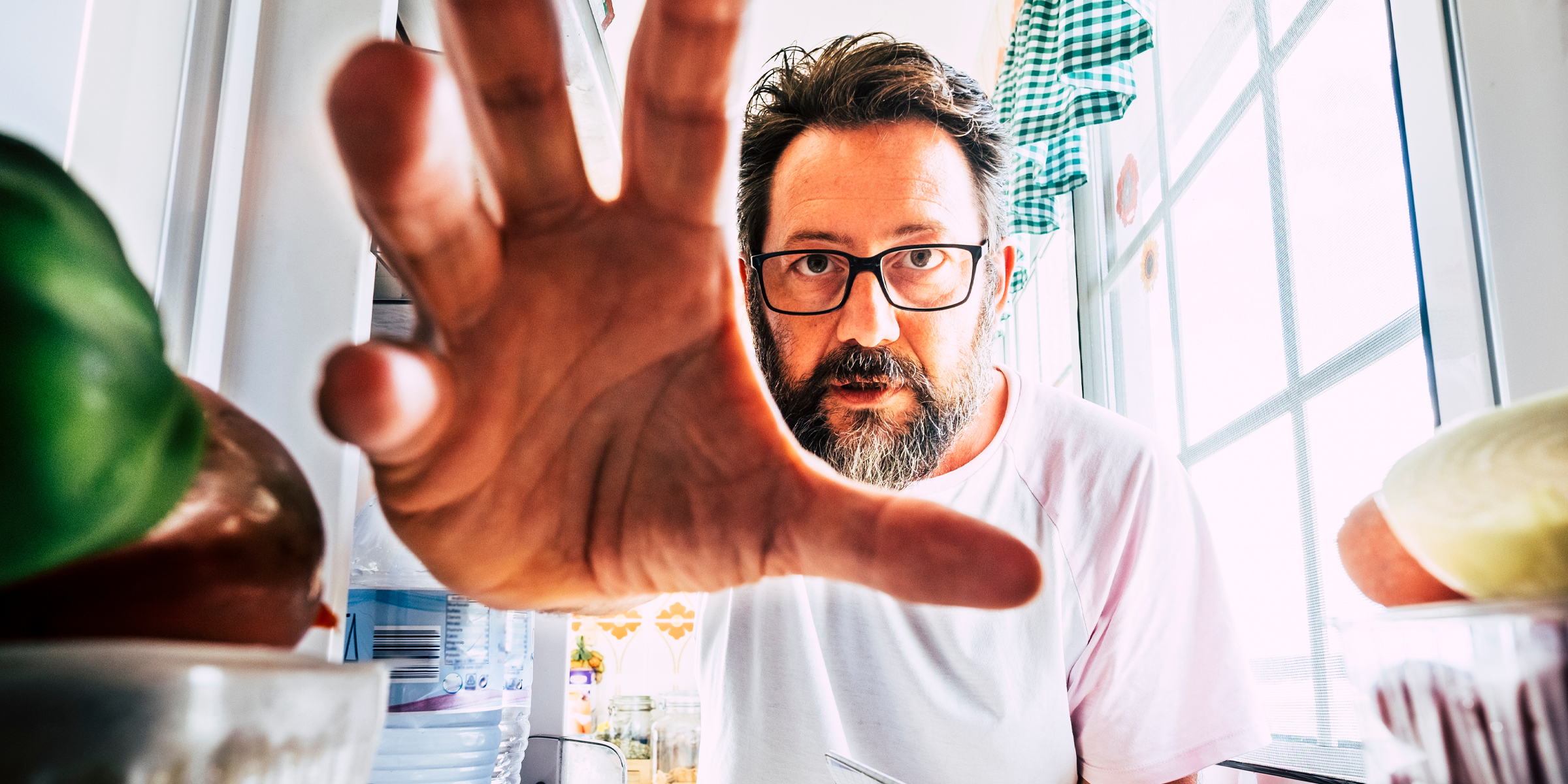 Hombre tomando comida del refrigerador | Fuente: Shutterstock