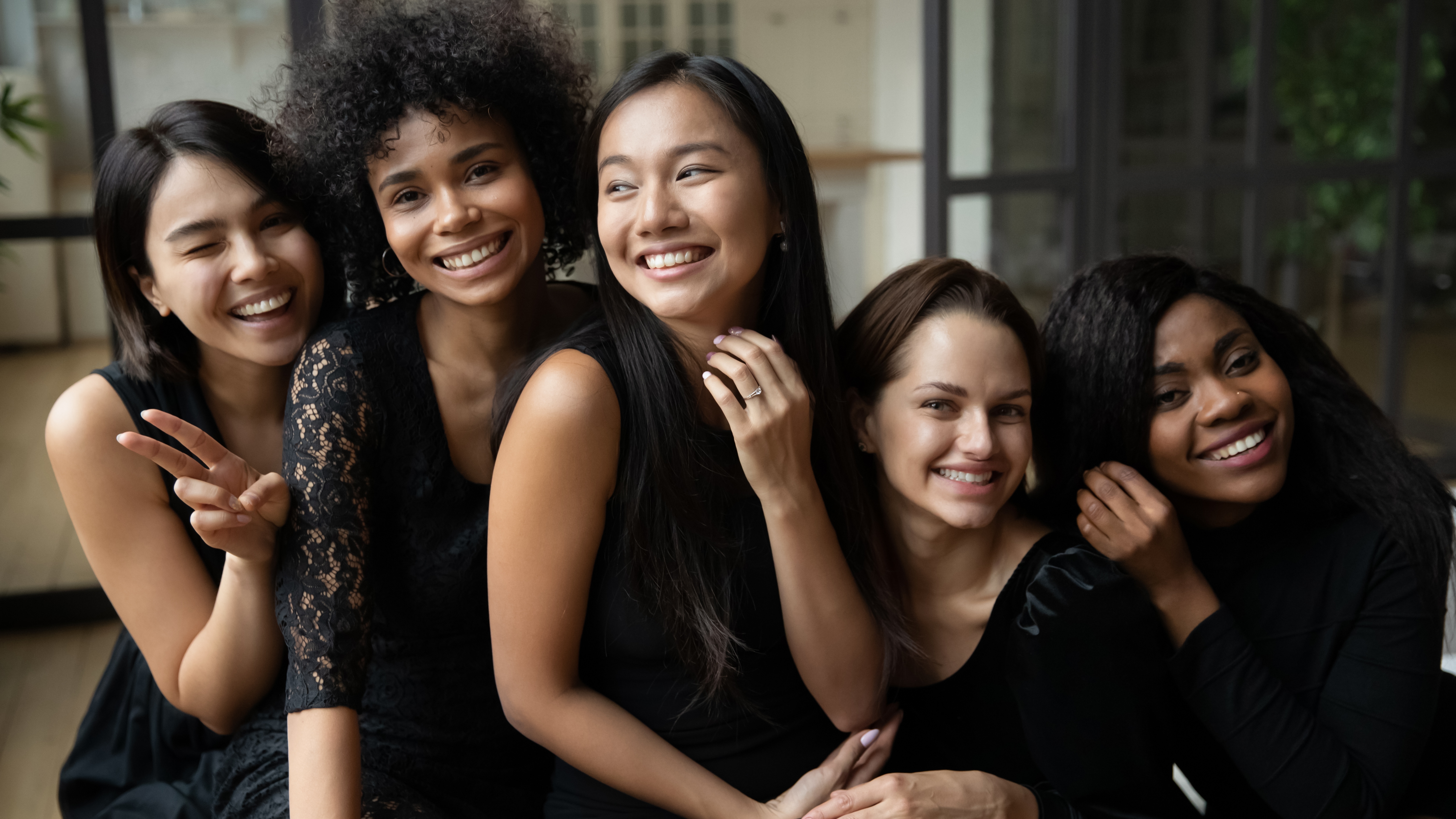 Mujeres vestidas de negro sonriendo | Fuente: Shutterstock