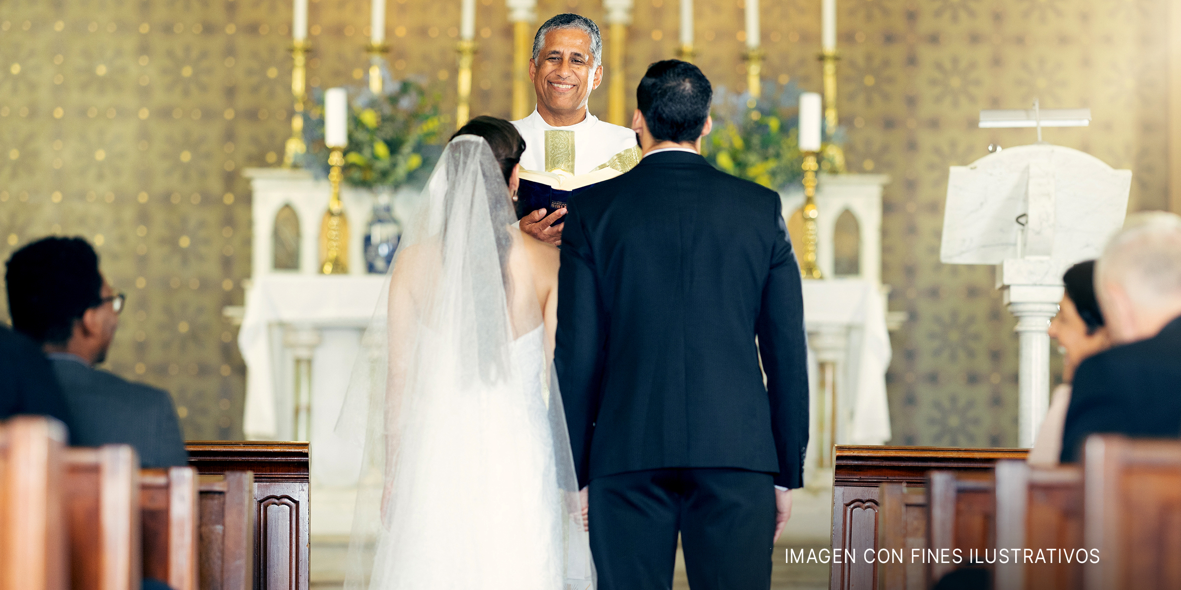 Pareja de pie ante el sacerdote en la iglesia | Foto: Shutterstock
