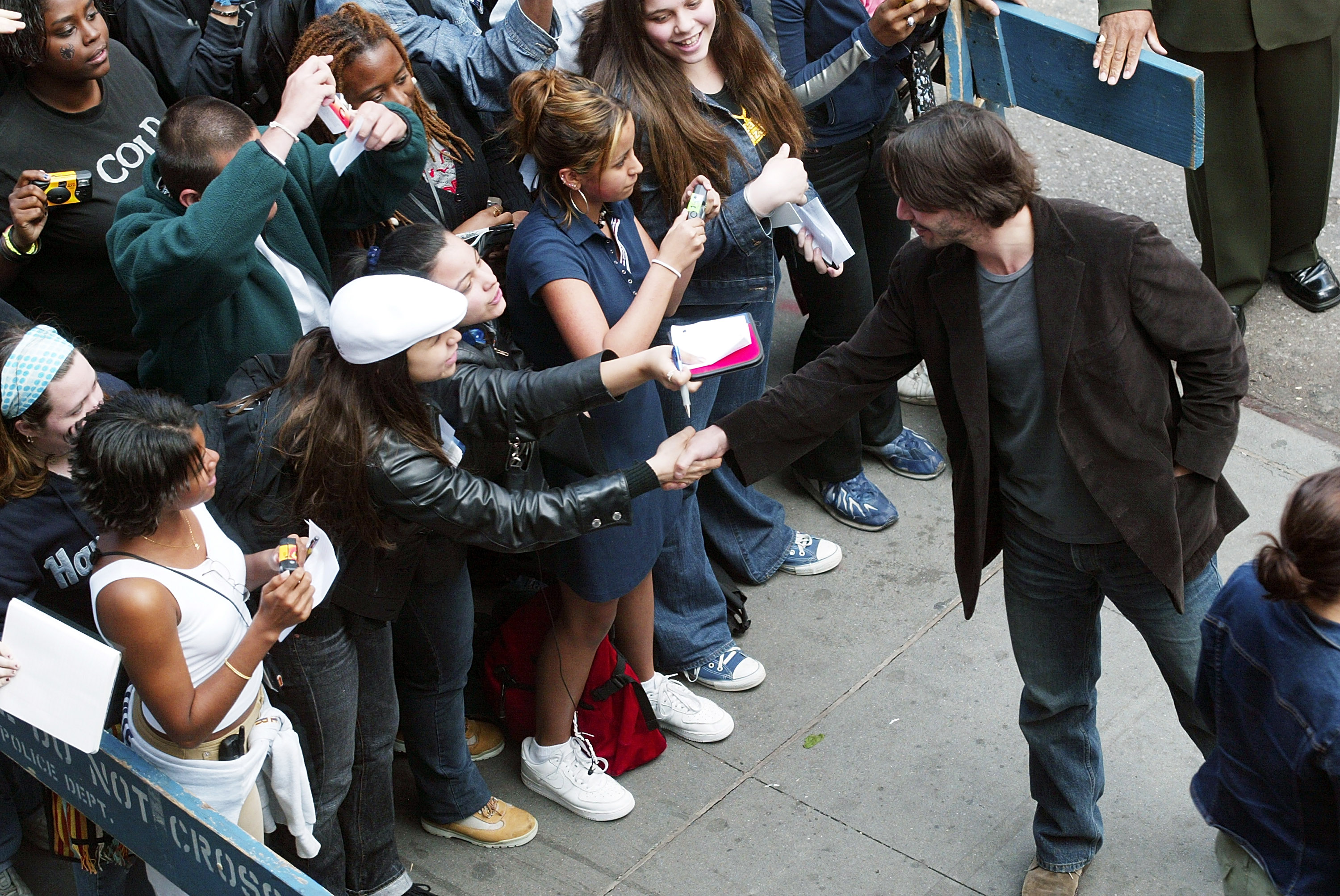 Keanu Reeves saluda a los fans durante una visita del reparto de "The Matrix Reloaded" en Nueva York, el 13 de mayo de 2003. | Fuente: Getty Images