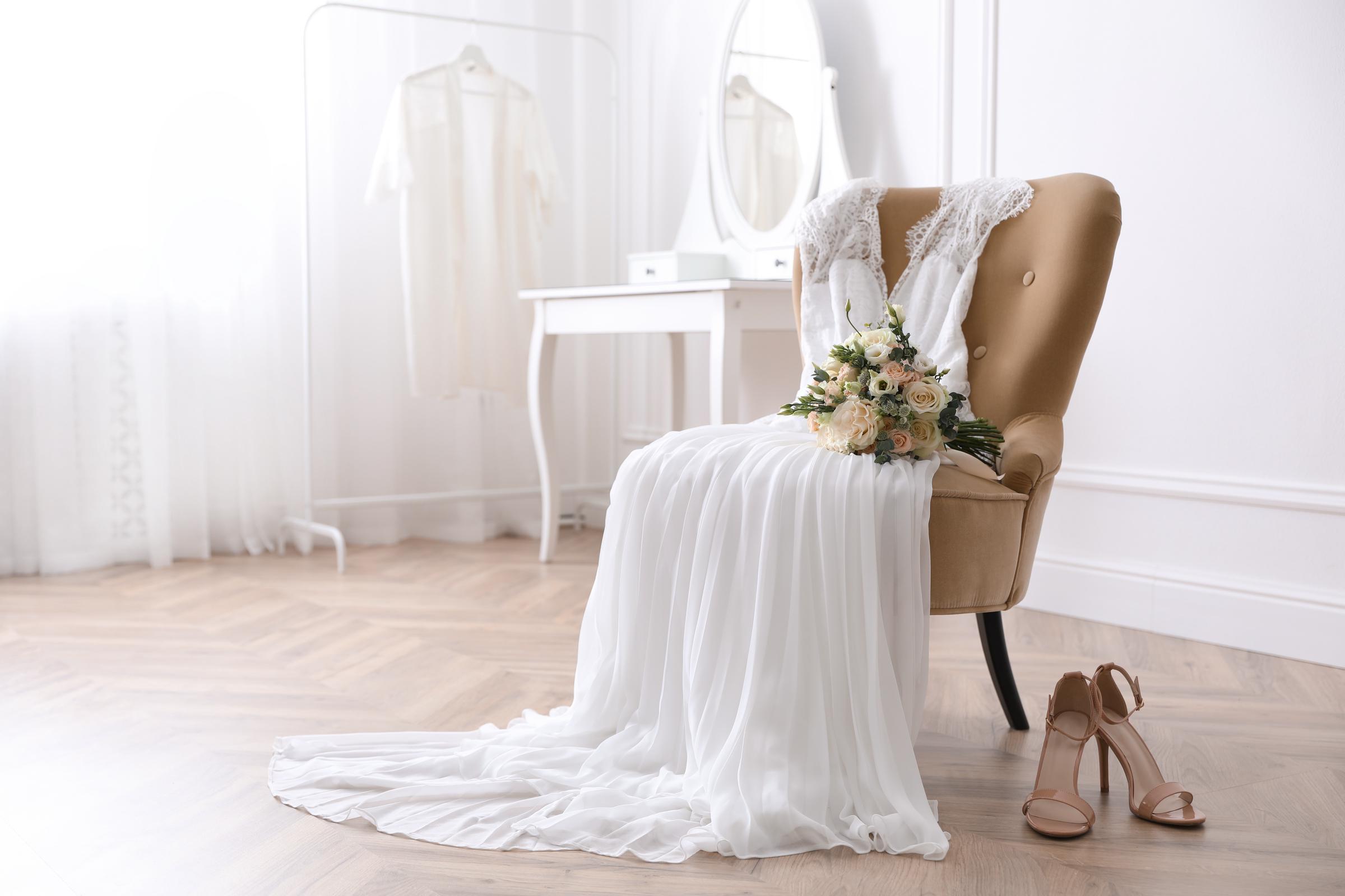 Un abito da sposa e delle scarpe in una stanza | Fonte: Shutterstock