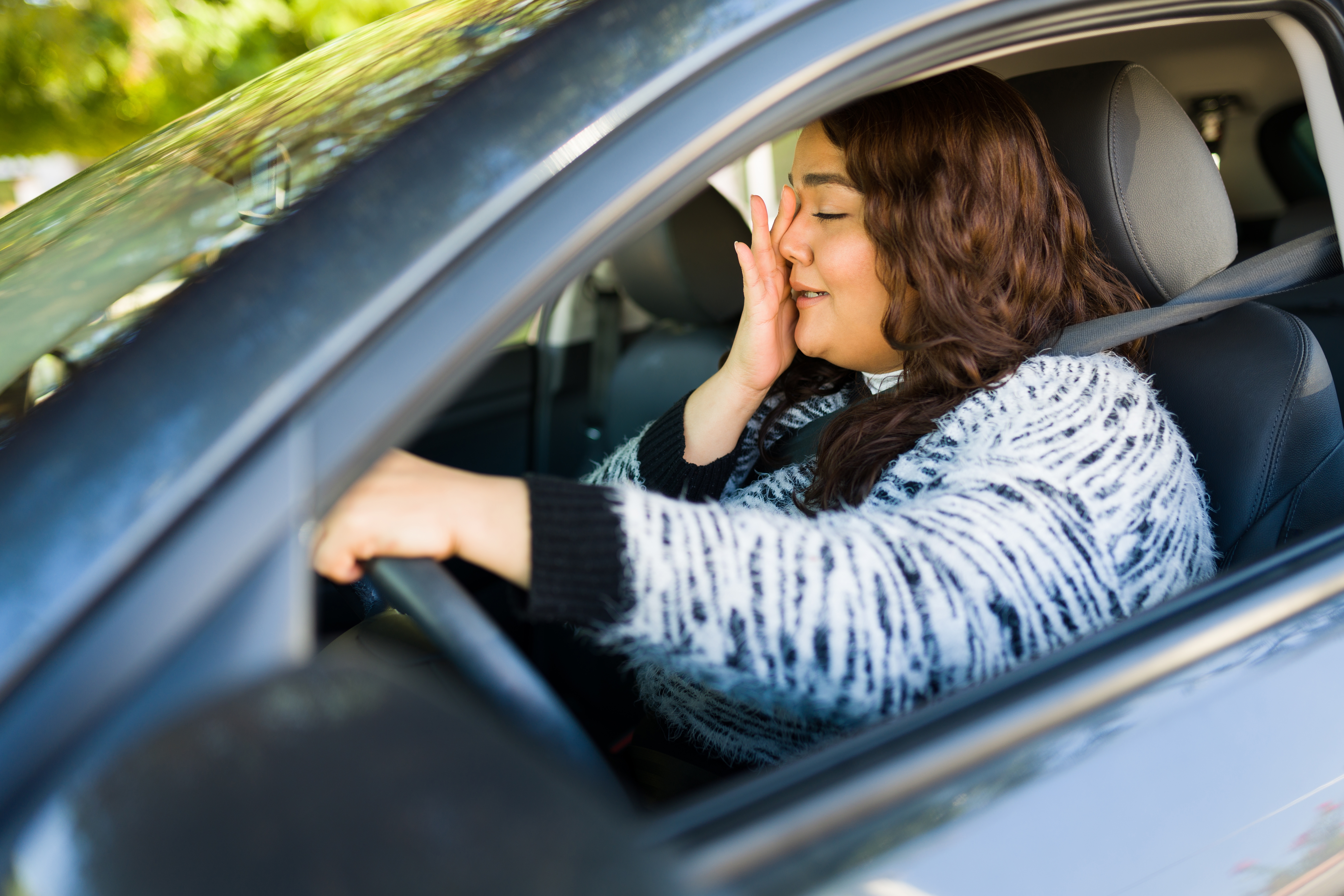 Una mujer llora mientras conduce un automóvil. | Foto: Shutterstock