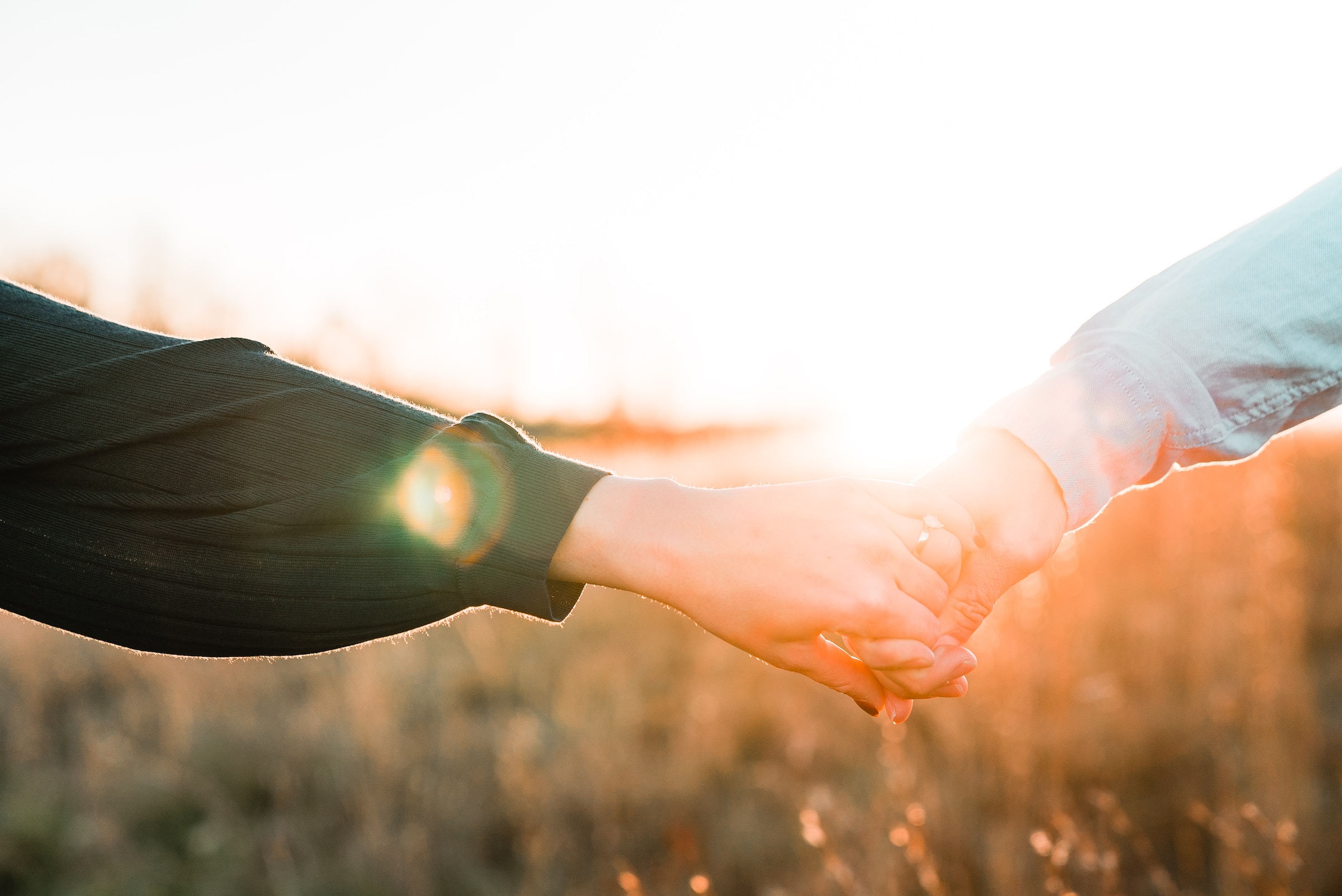 Una pareja tomada de la mano al sol. | Foto: Unsplash