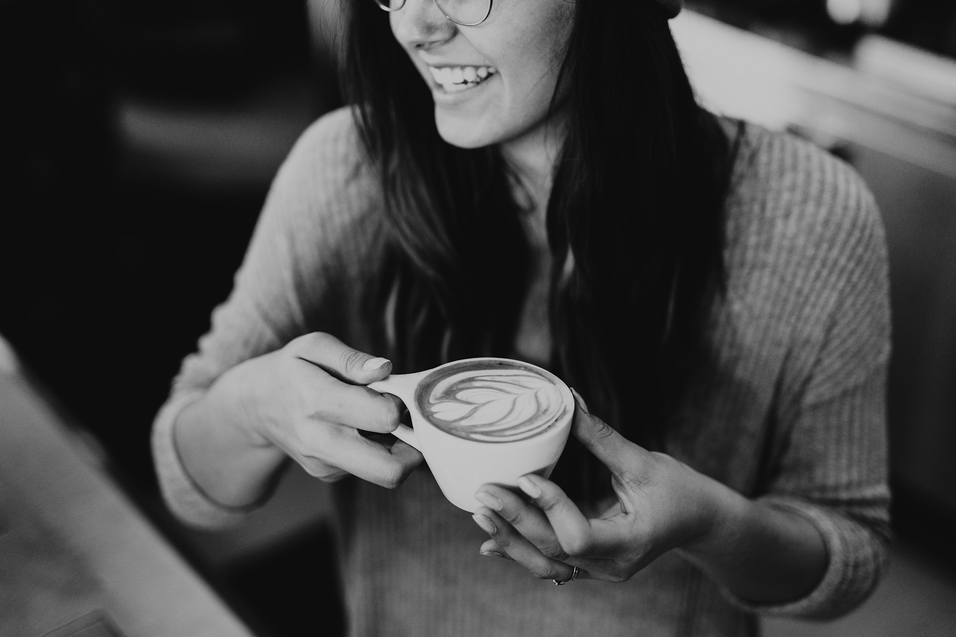 Una mujer riendo mientras sostiene una taza de café | Fuente: Unsplash