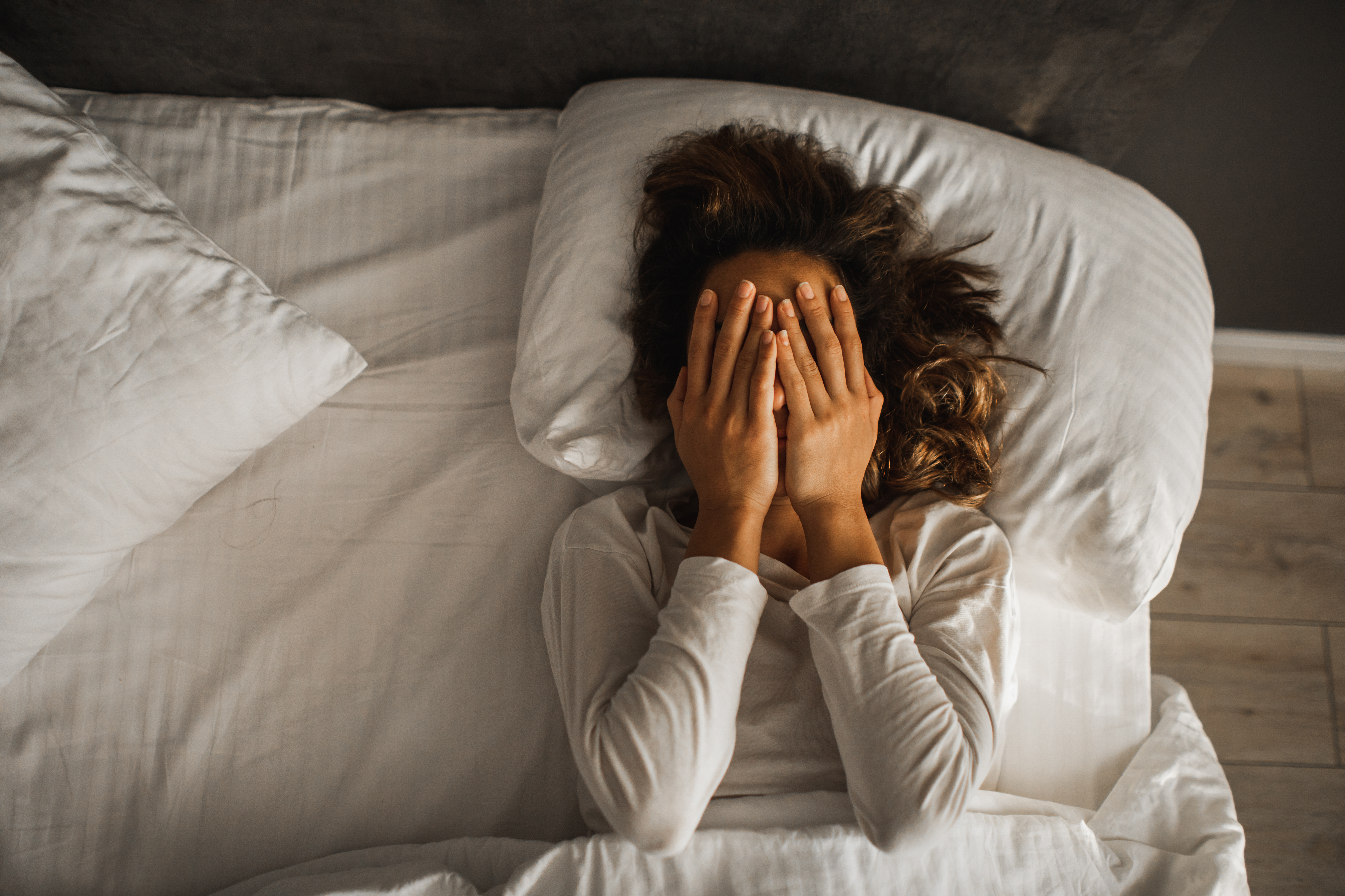 Una mujer triste en la cama | Foto: Getty Images
