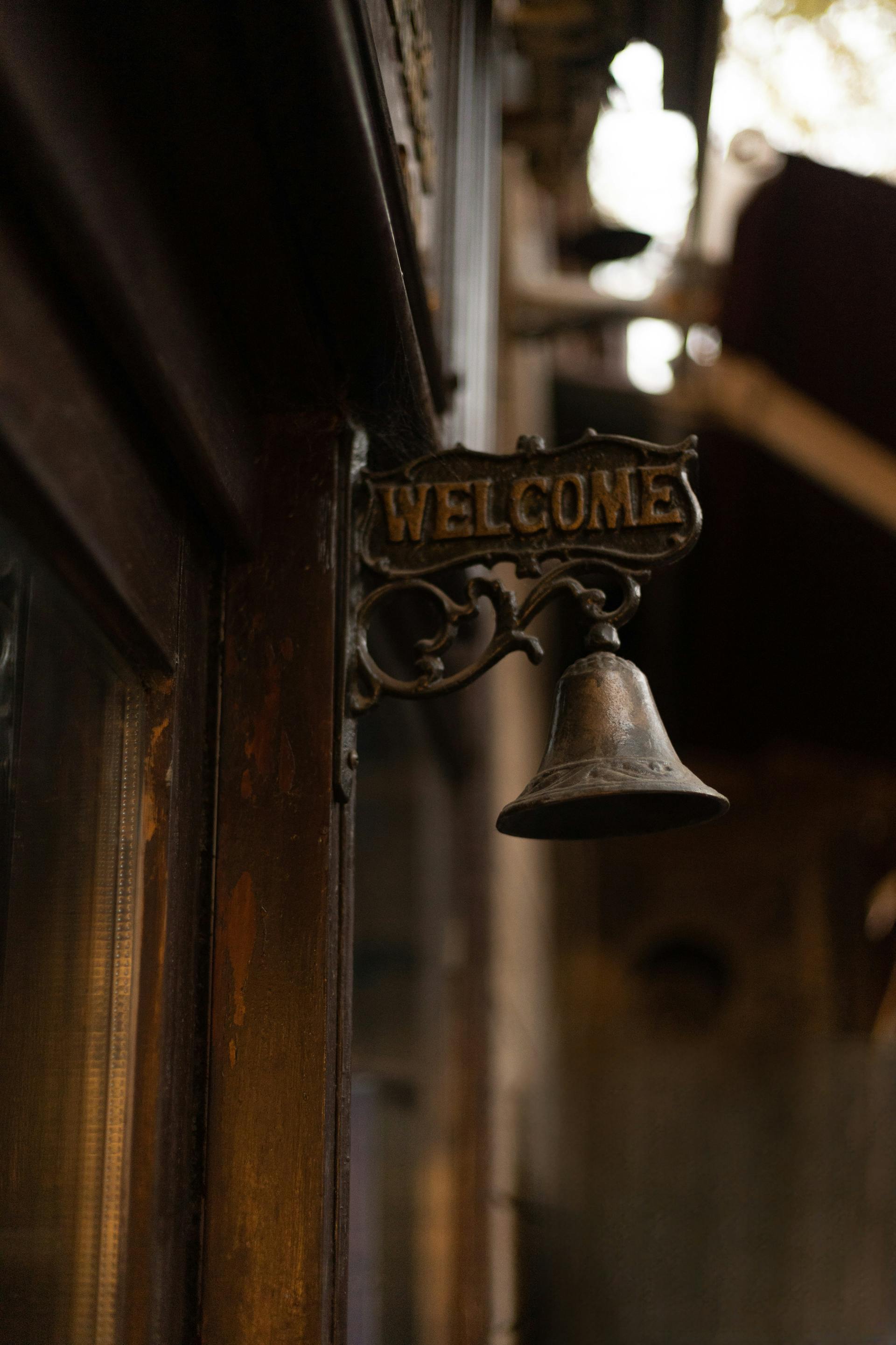 Una campana de latón sobre una puerta de madera | Fuente: Pexels