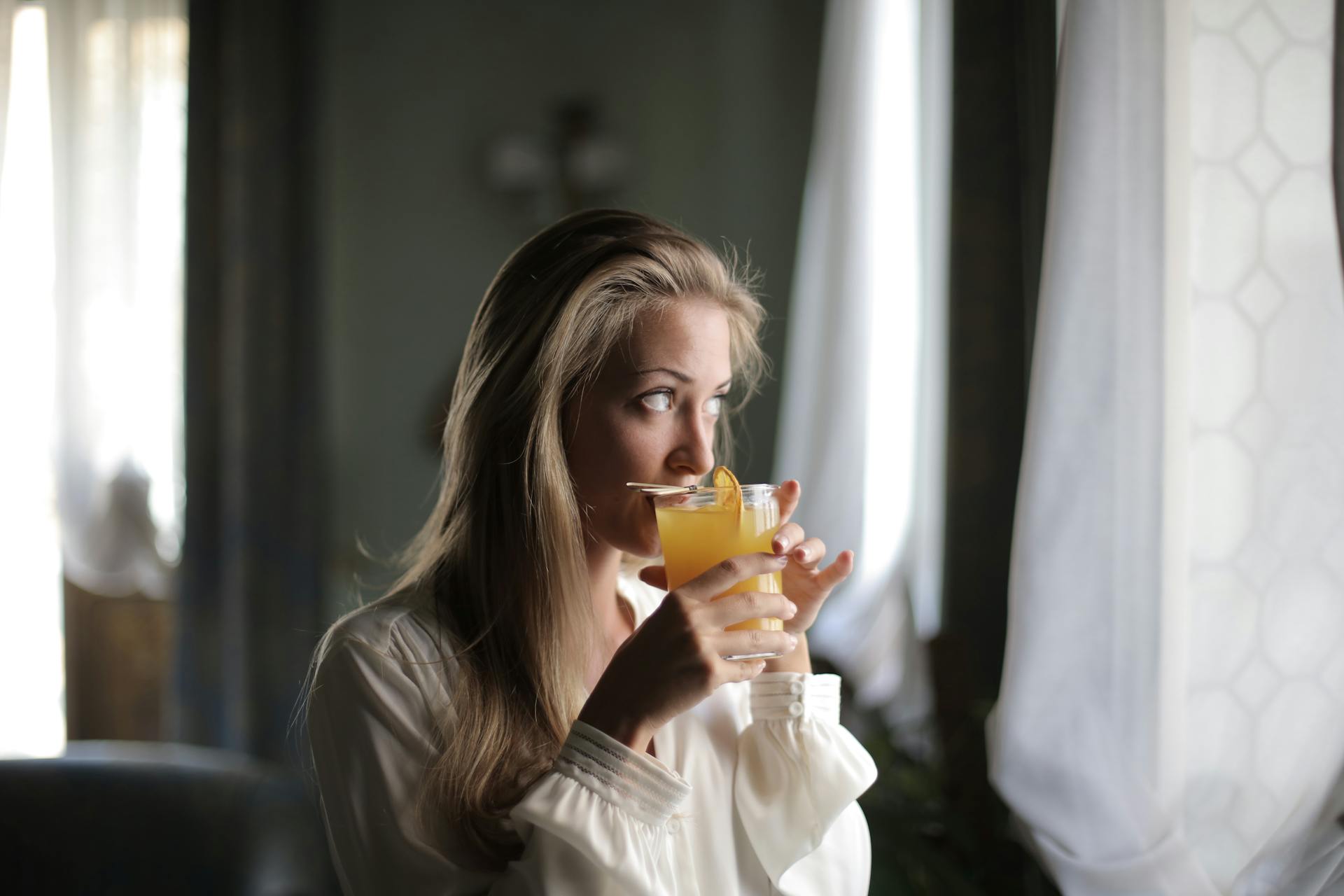 Mujer bebiendo zumo de naranja | Foto: Pexels
