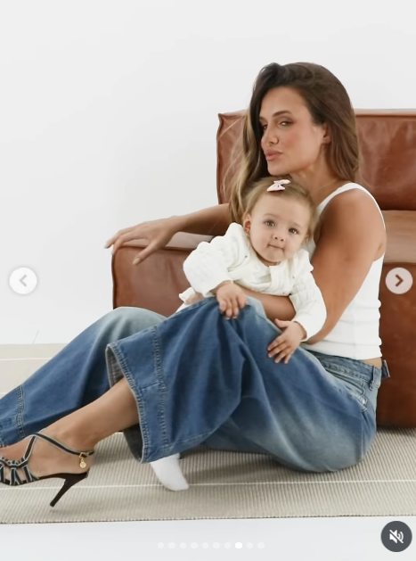 En otra toma de la campaña, Camila descansó un brazo sobre el respaldo del sillón mientras sostenía a su hija con el otro, exhibiendo su calzado de tiras finas con tacón aguja. La modelo lució su cabellera suelta con ondas suaves y Aitana miró con ternura directamente hacia el lente. | Fuente: Instagram/camihoms