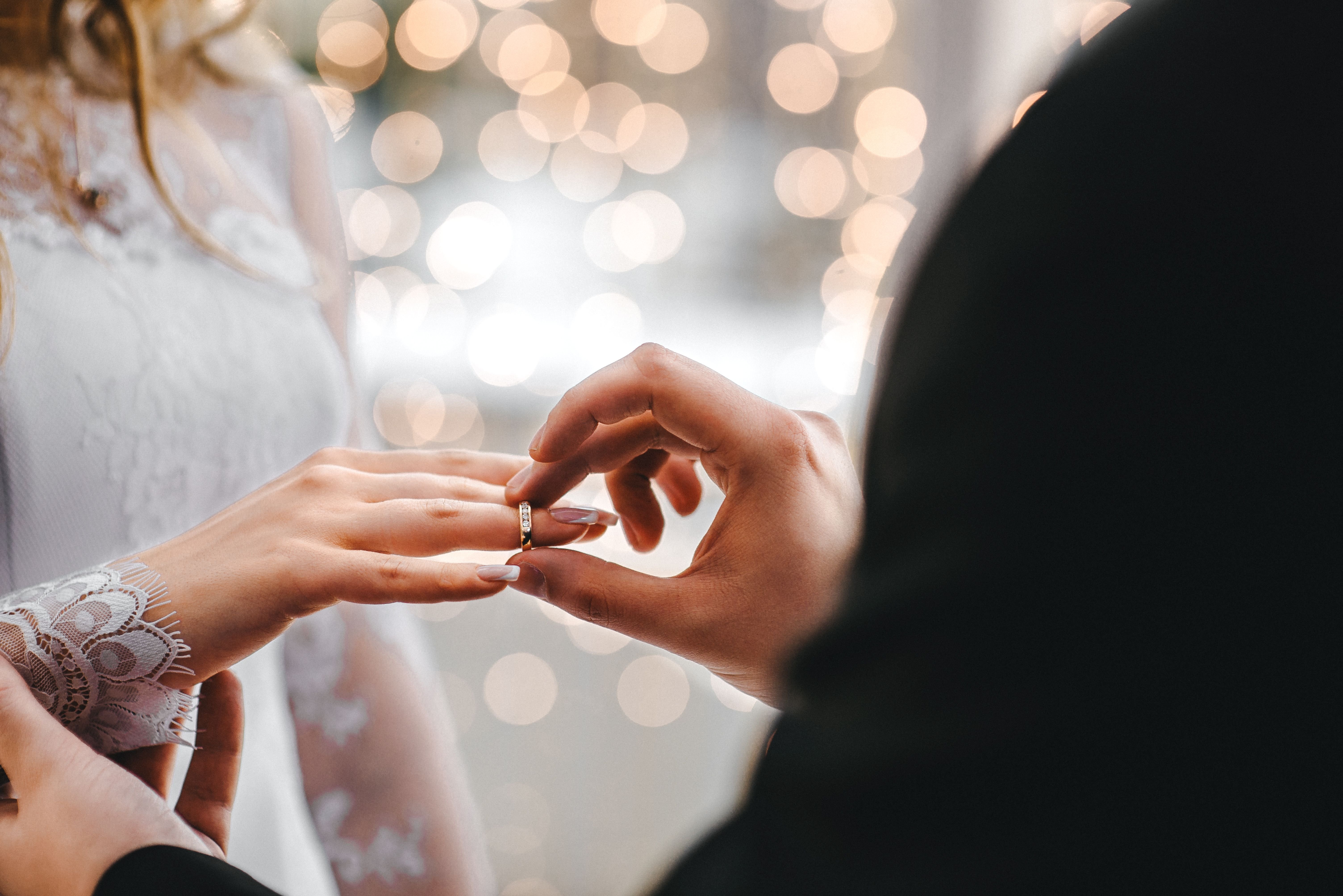 El novio introduce un anillo matrimonial en el dedo de la novia. | Foto: Pexels 