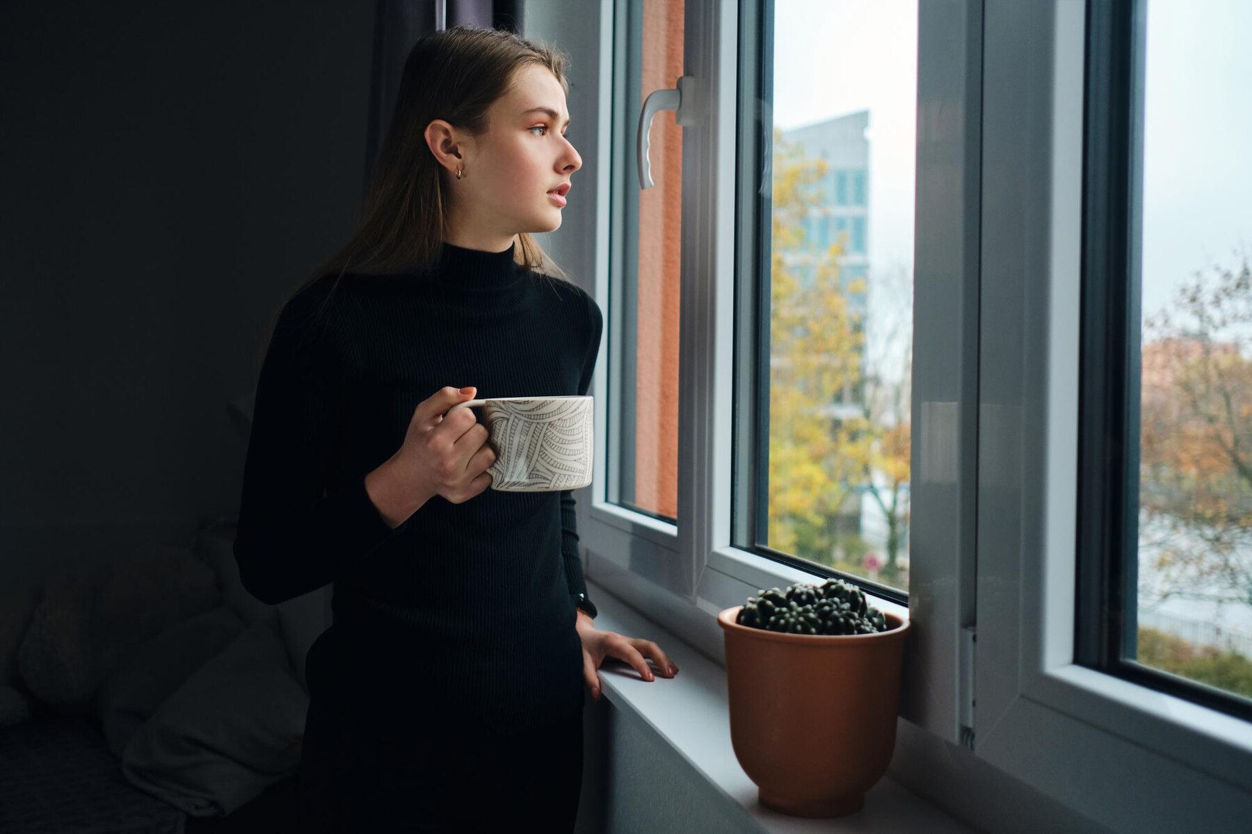 Una mujer preocupada mirando por la ventana | Source: Freepik