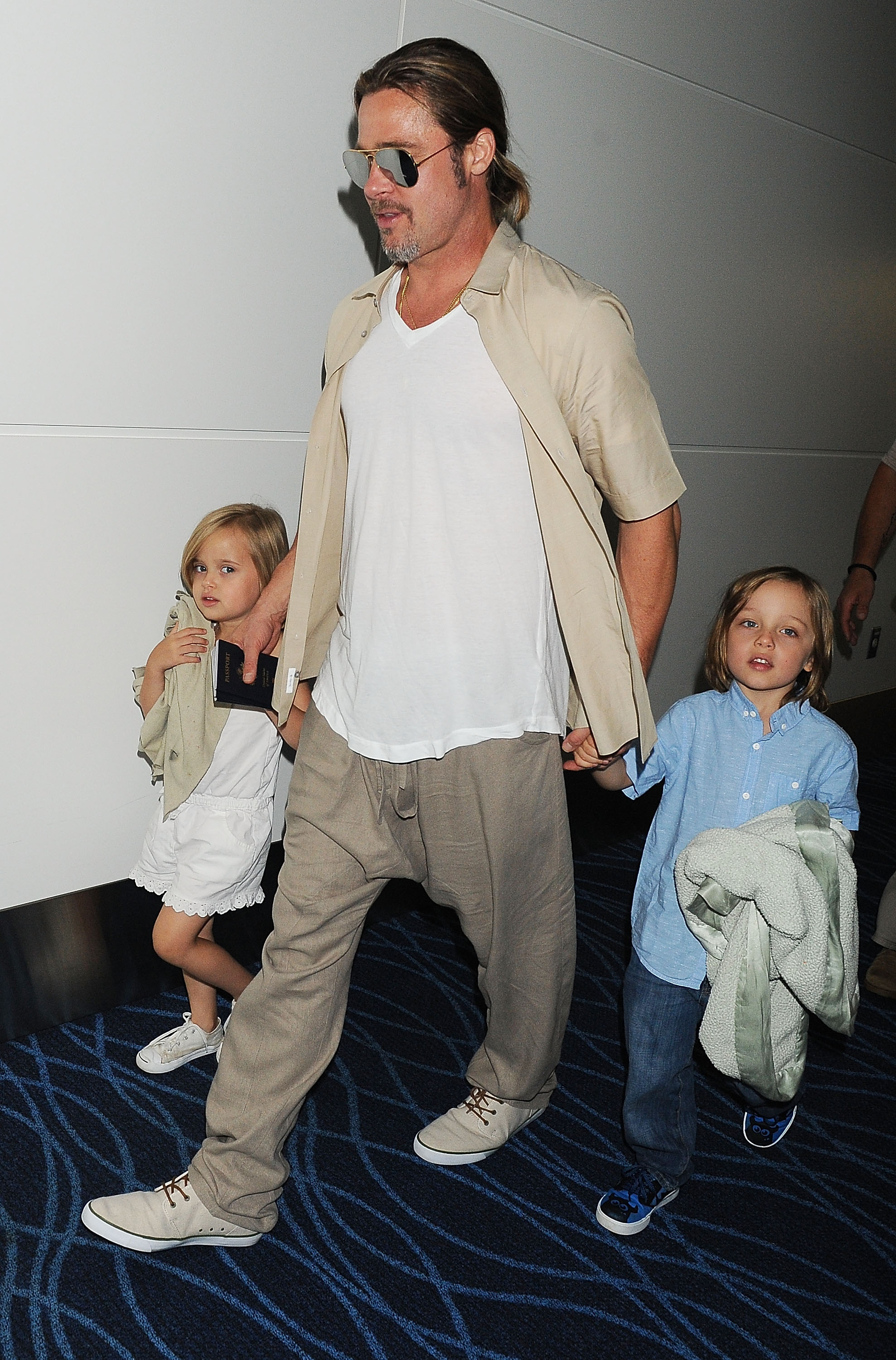Brad Pitt y sus hijos gemelos Knox y Vivienne Jolie-Pitt el 30 de julio de 2013, en Tokio, Japón | Fuente: Getty Images