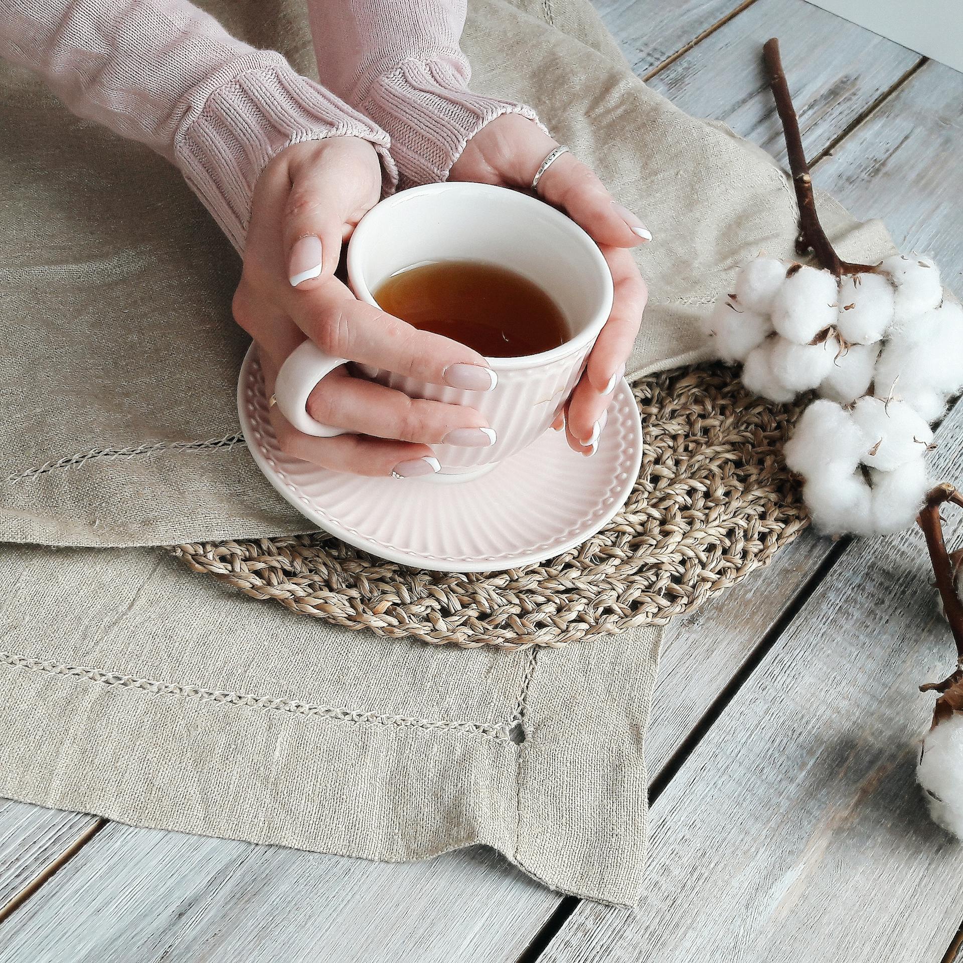 Las manos de una mujer alrededor de una taza de té | Fuente: Pexels