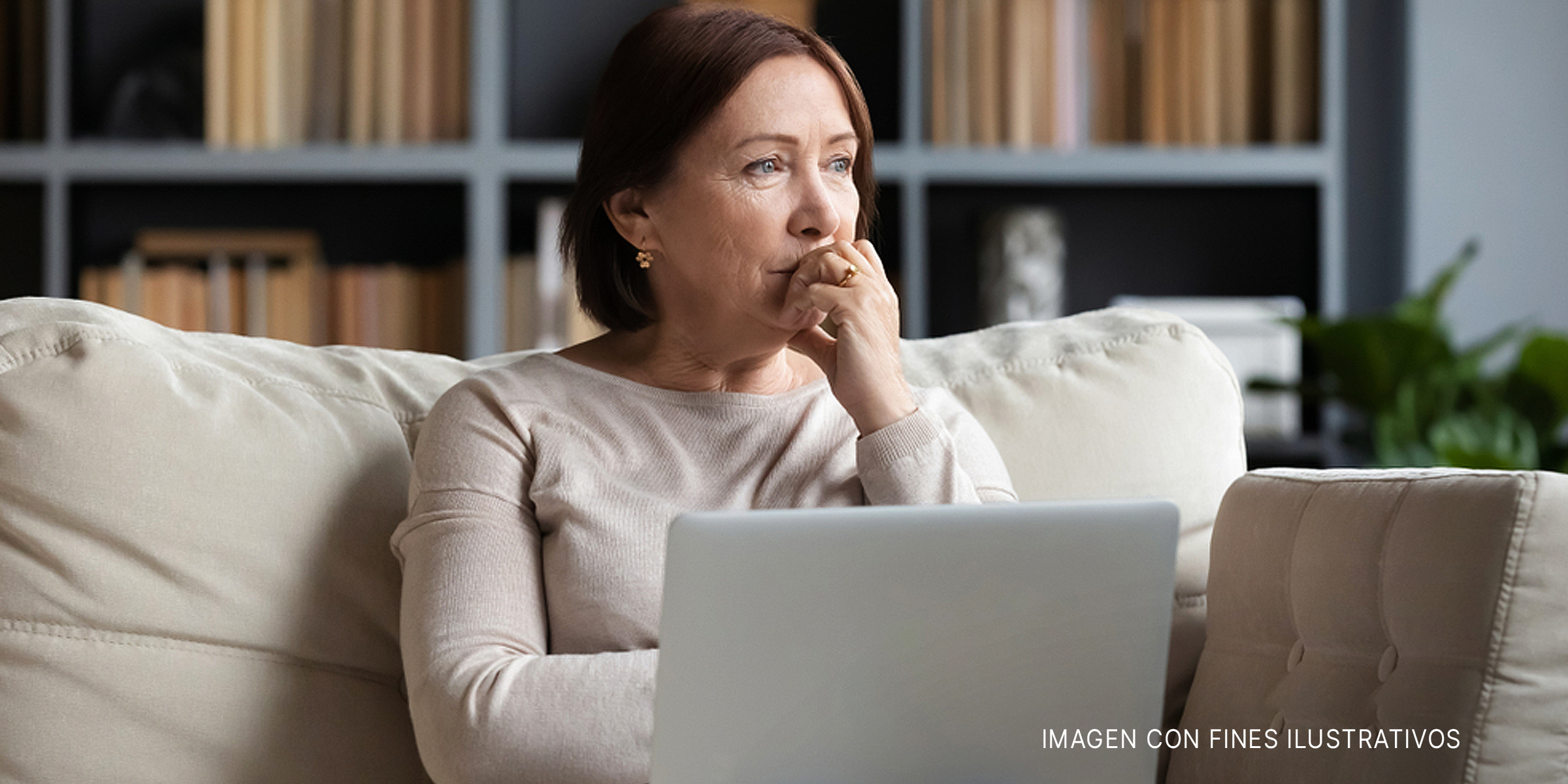 Mujer preocupada con un portátil mirando hacia otro lado | Foto: Shutterstock