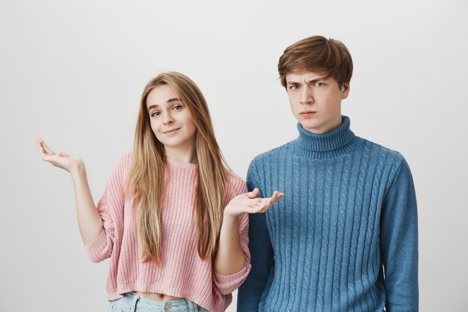 Una joven encogiéndose de hombros junto a un adolescente molesto | Fuente: Freepik