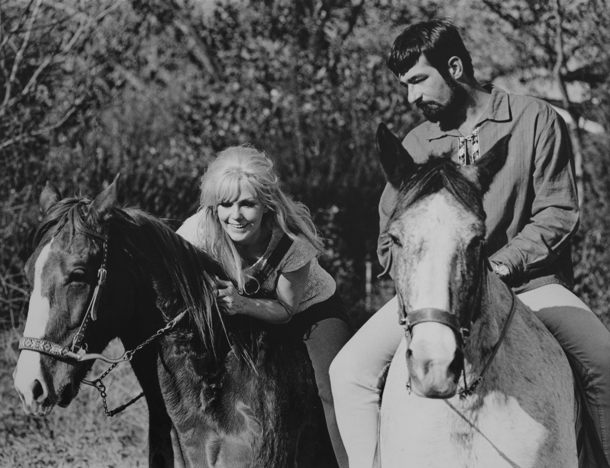 Kim Novak y el dueño del restaurante Joel Thomas montan a caballo juntos en Burbank, California, durante una excursión al aire libre. | Fuente: Getty Images