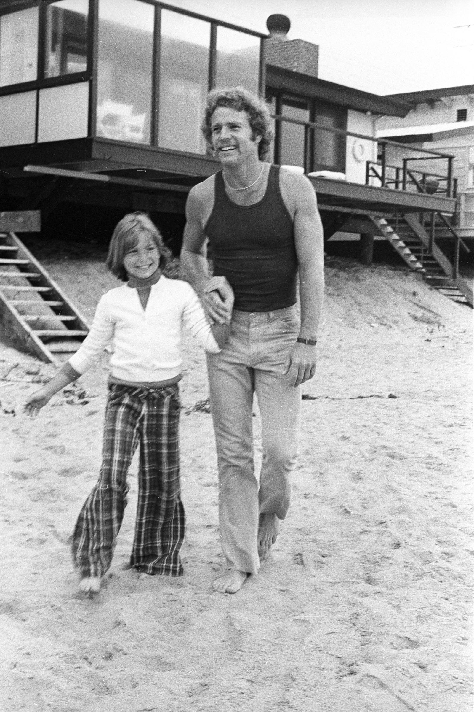 Ryan O'Neal con su hija durante una entrevista con Women's Wear Daily el 27 de abril de 1973, en Malibú, California | Fuente: Getty Images