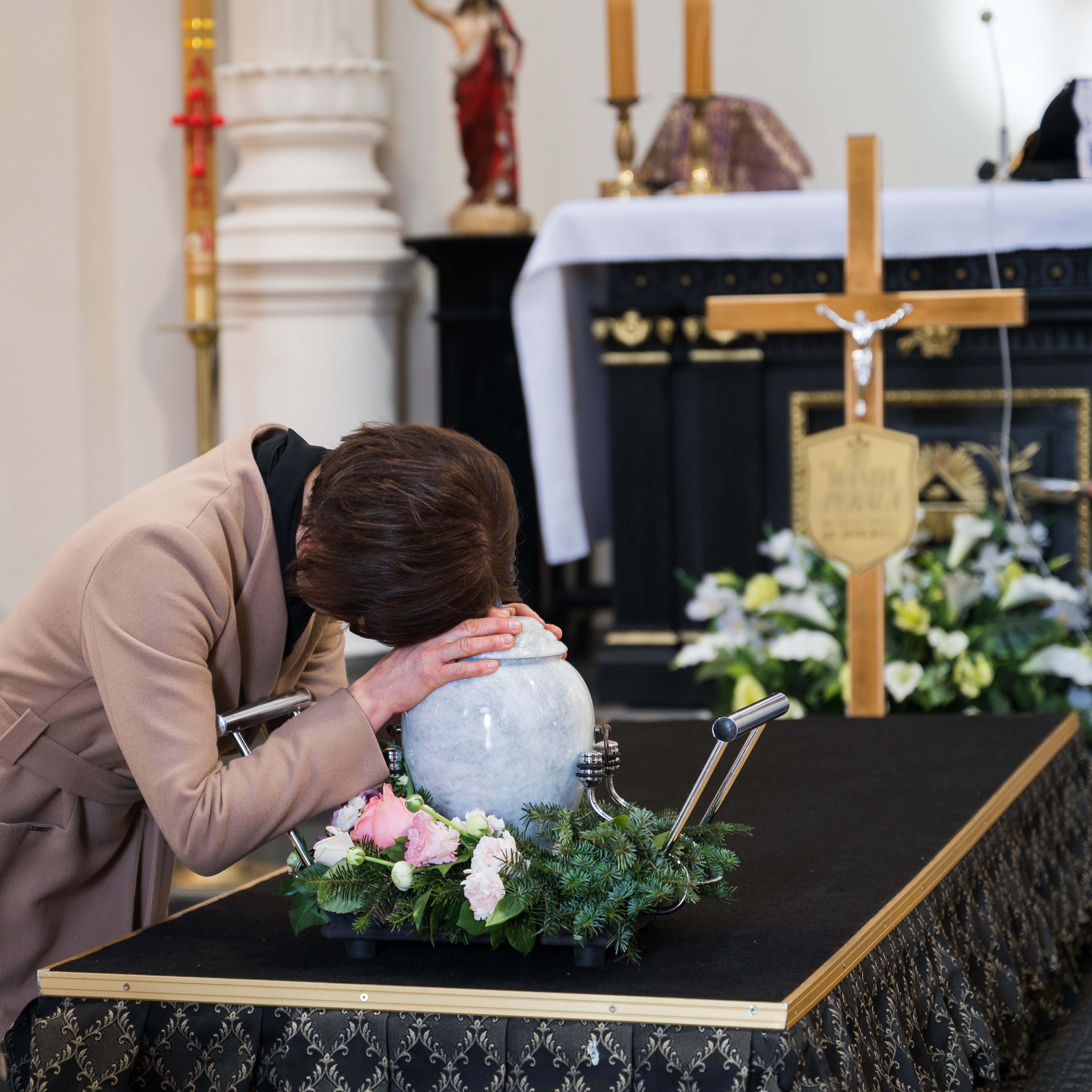 Una mujer llora sobre la urna de un ser querido durante un funeral | Foto: Shutterstock