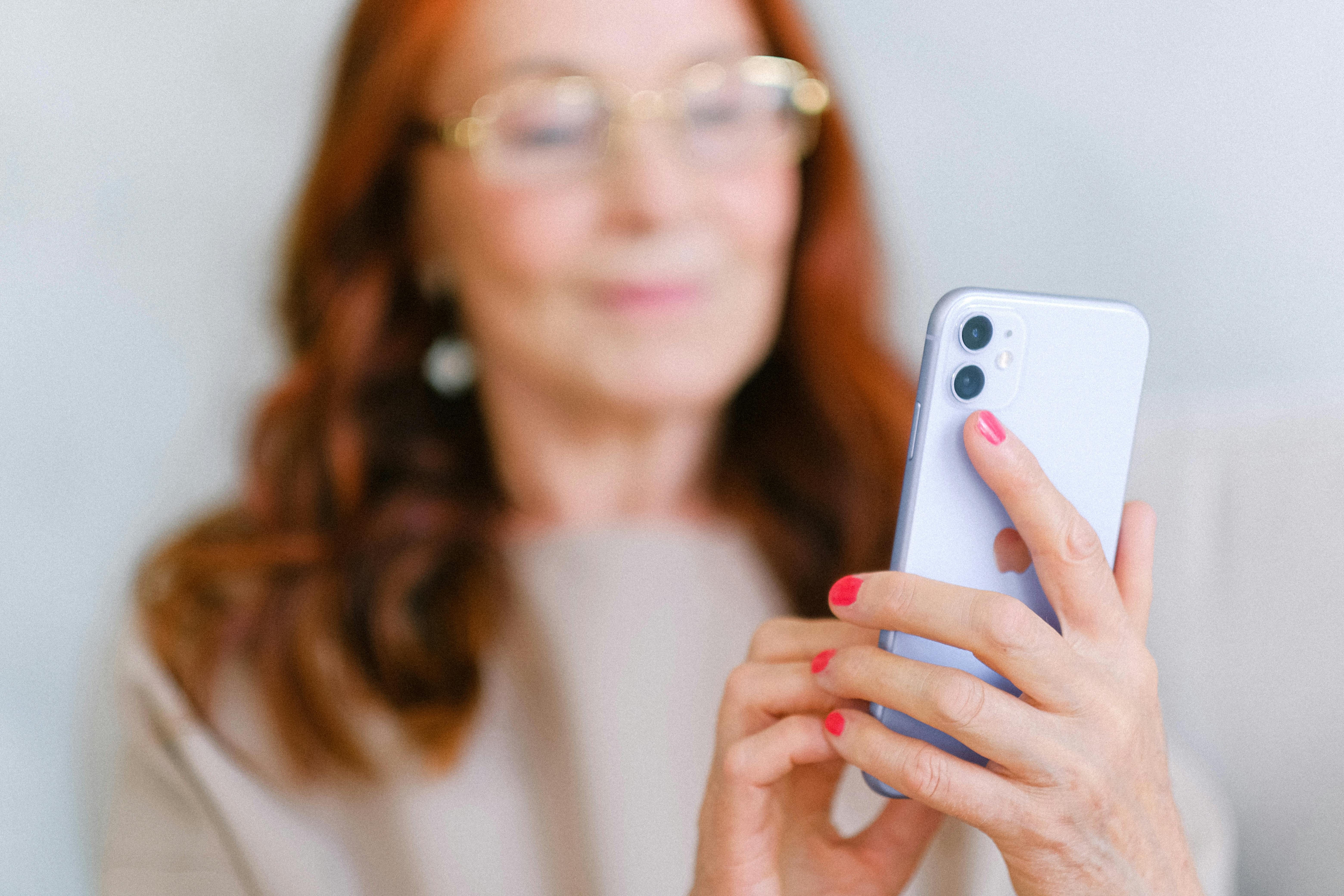 Una mujer mayor sujetando un teléfono inteligente | Fuente: Pexels