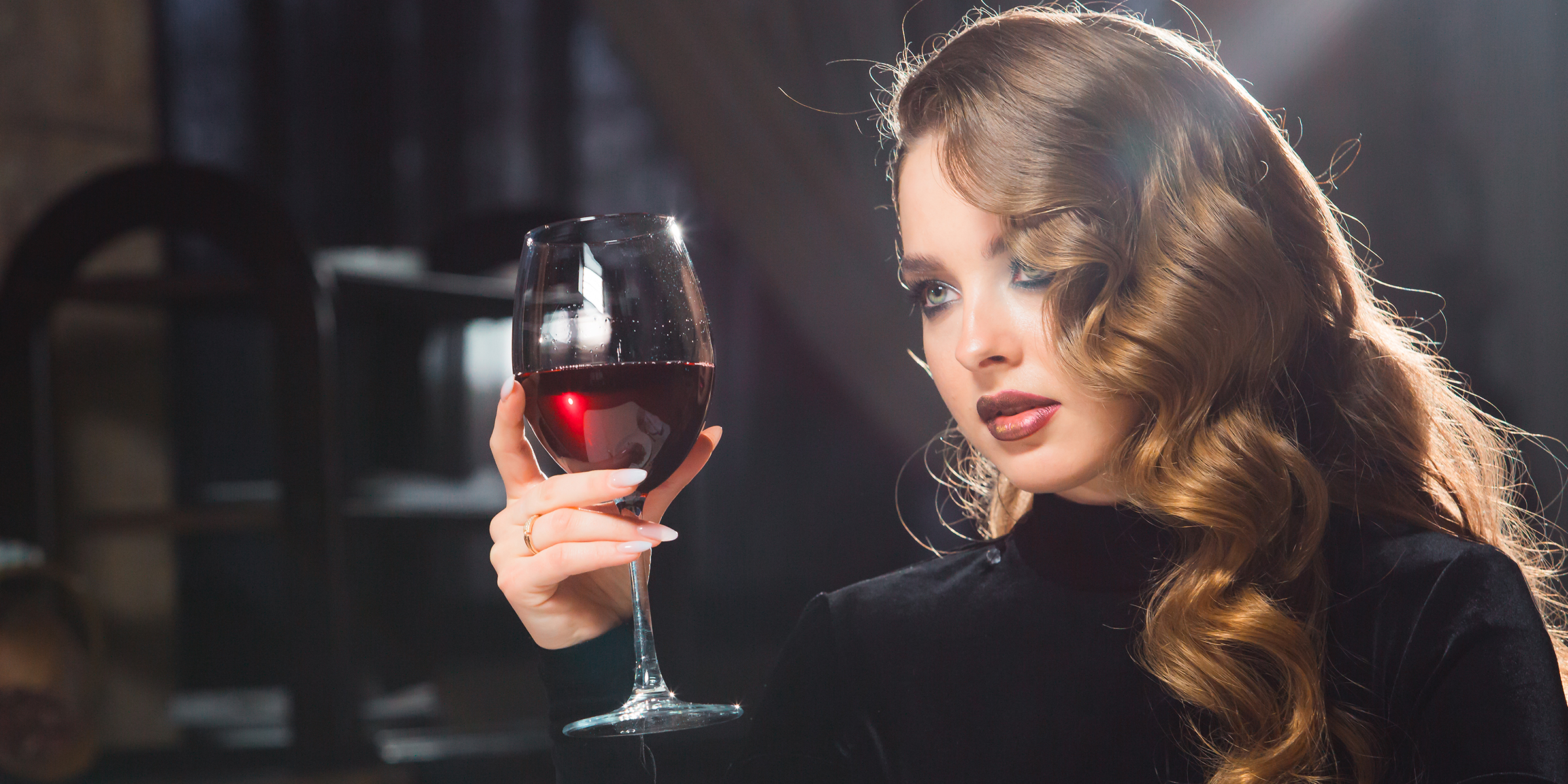 Una mujer con una copa de vino en la mano | Fuente: Shutterstock