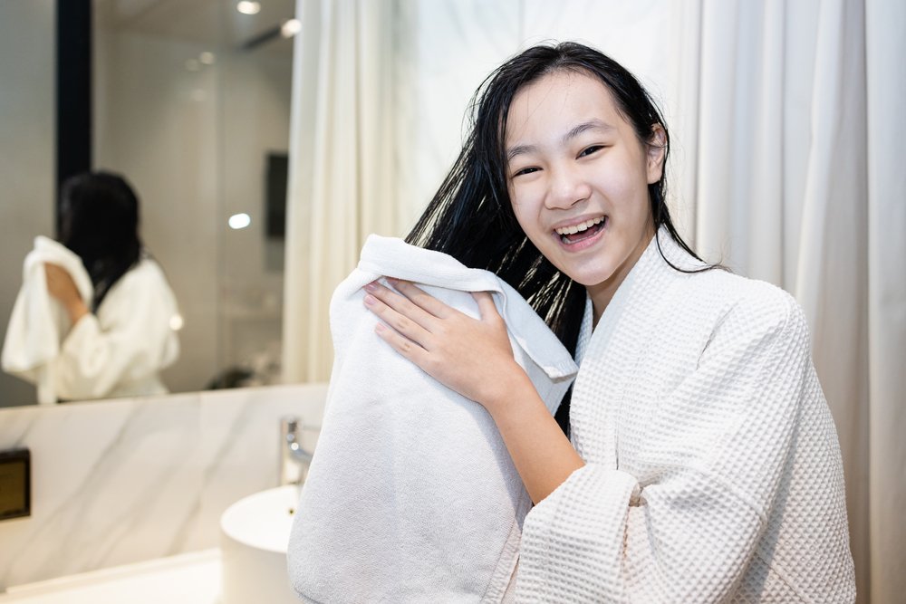 Mujer secando su cabello con una toalla. | Foto: Shutterstock