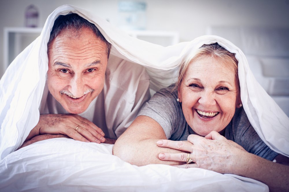 Pareja riendo en cama. Fuente: Shutterstock