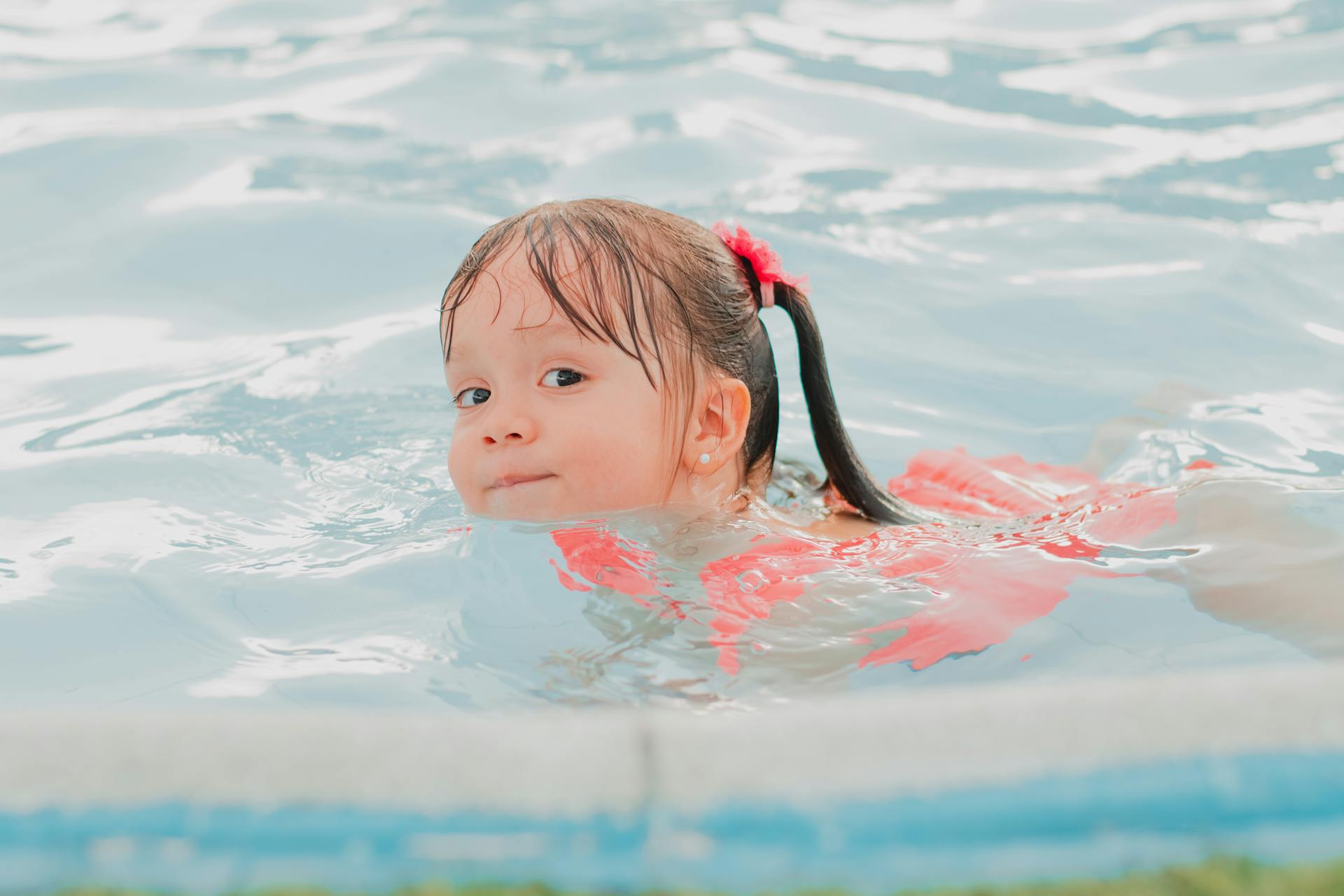 Una niña en una piscina | Foto: Unsplash