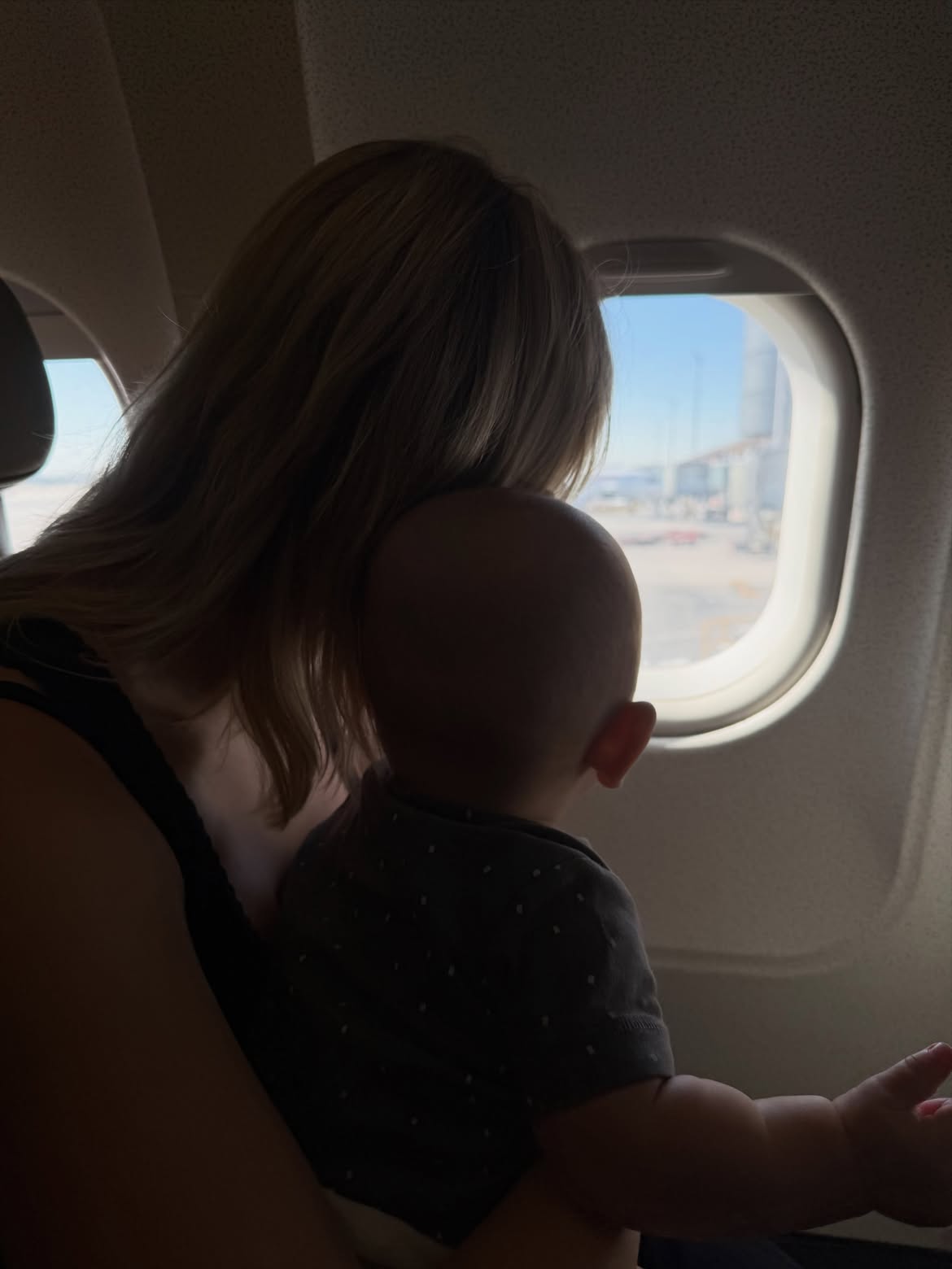 Úrsula Corberó con el pequeño Dante en su regazo mientras mira por la ventanilla de un avión | Fuente: Instagram/claradarin