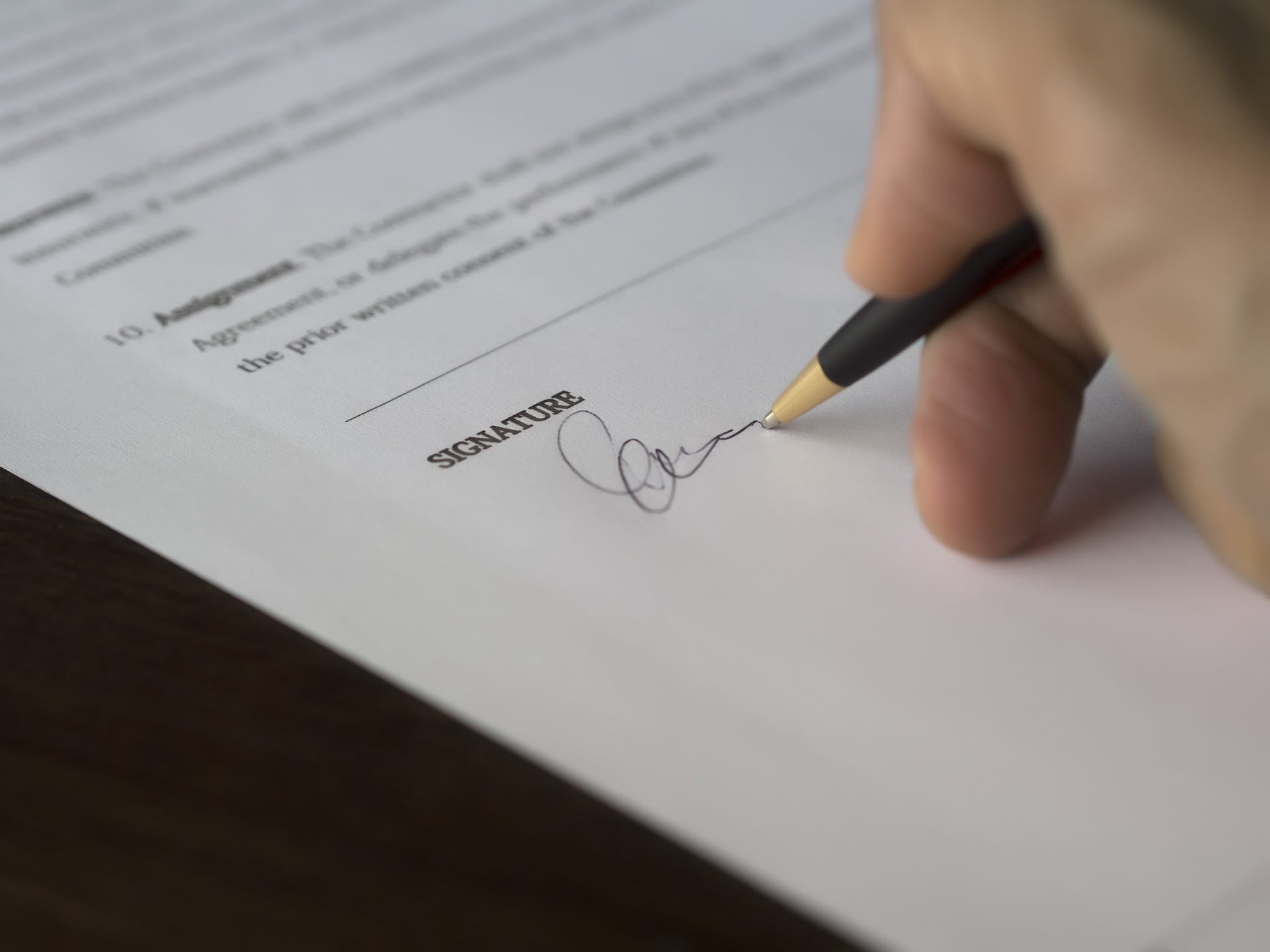 Persona firmando papeles | Foto: Pexels