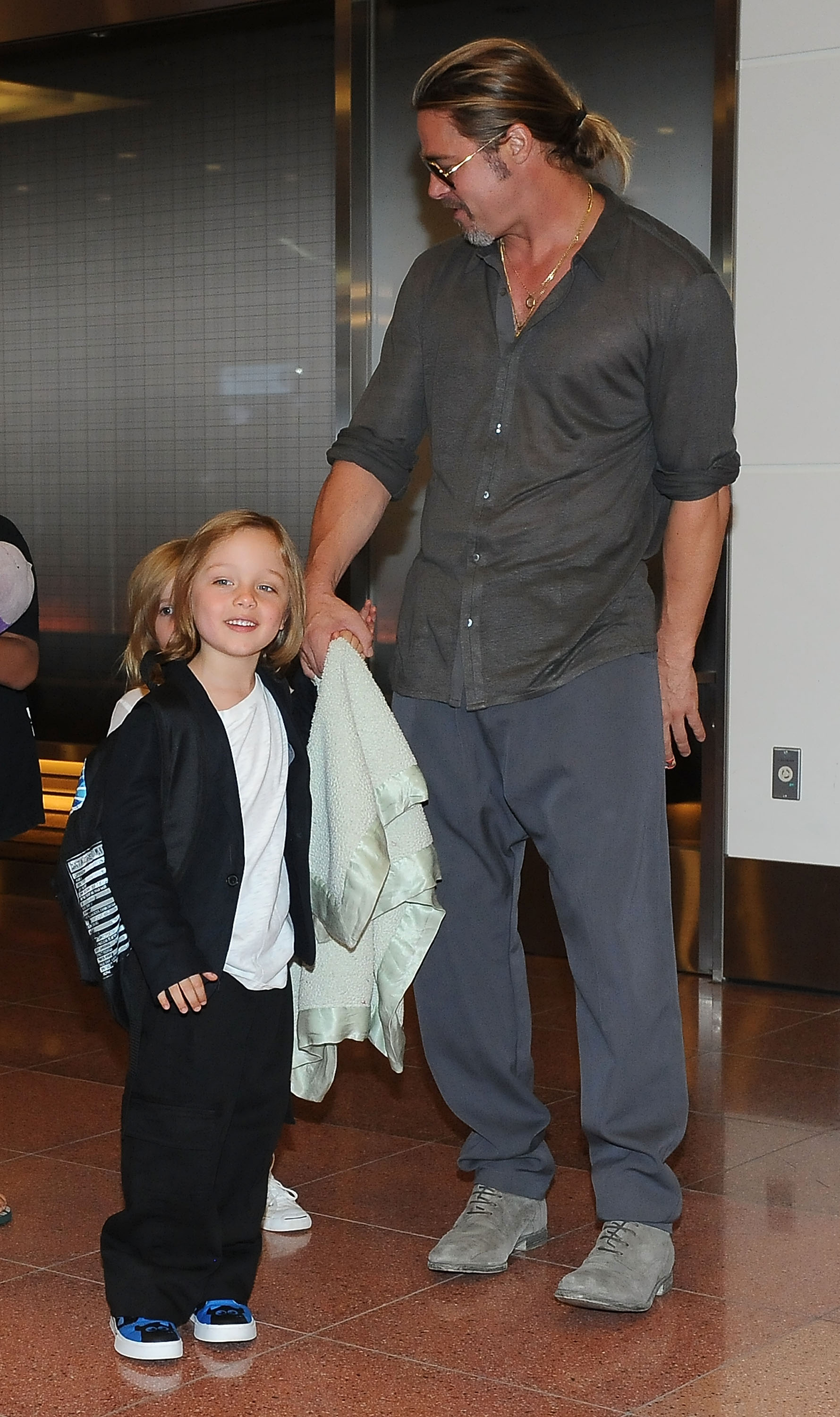 Brad Pitt y Knox Jolie-Pitt en el Aeropuerto Internacional de Tokio el 28 de julio de 2013, en Tokio, Japón. | Fuente: Getty Images